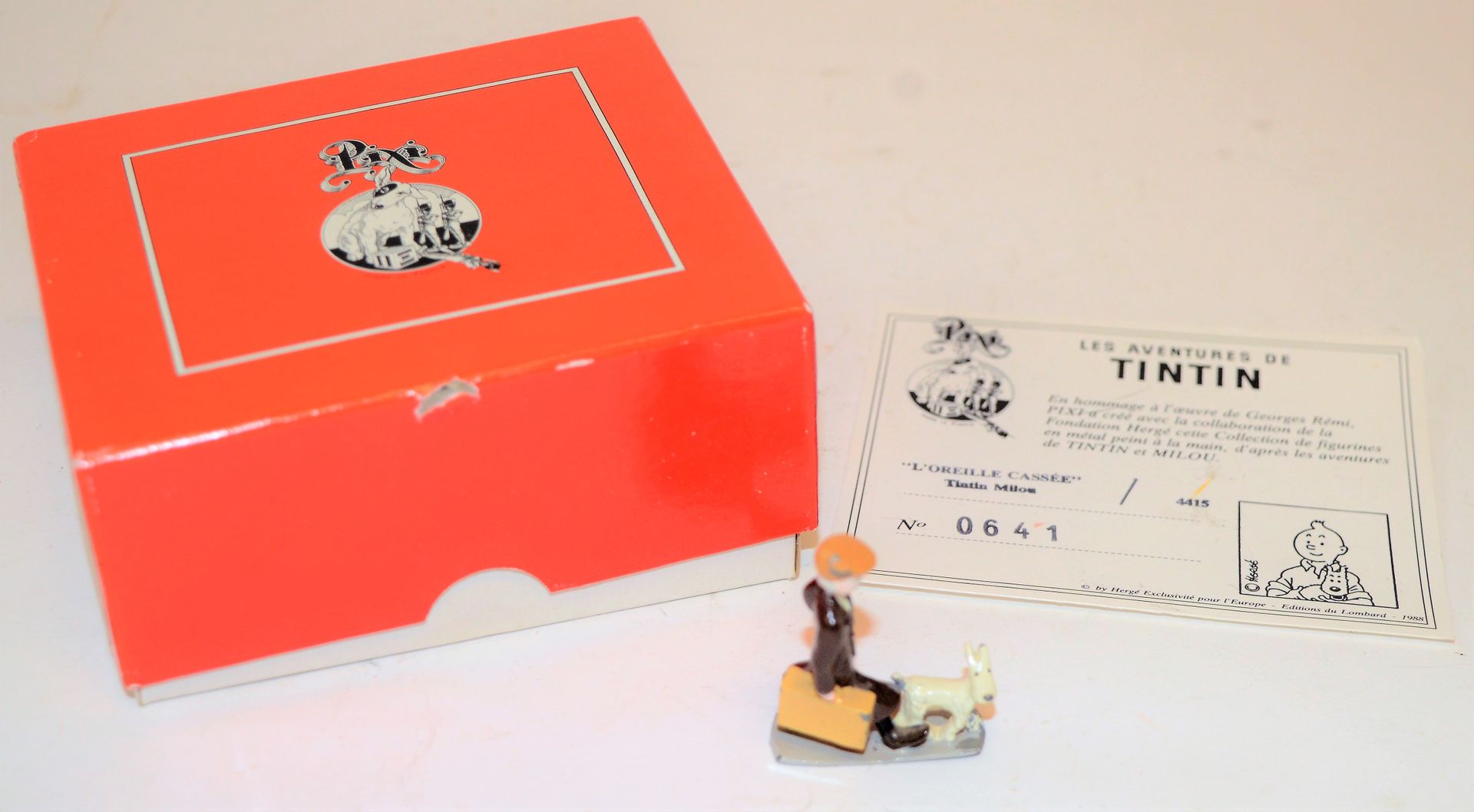 Null PIXI：丁丁-斯诺伊的 "破耳朵"。红色盒子，有插图的背景。1988年，版本1500册。 两个字上有油漆缺口。盒子在一个地方损坏。