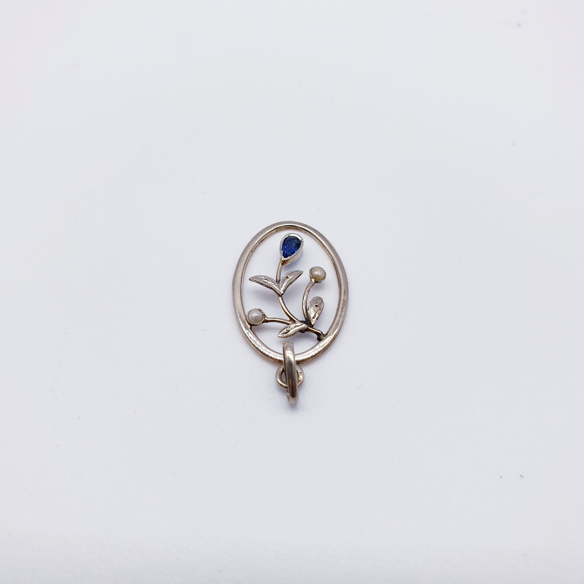 Null PENDENTIF ovale en or gris 750°, orné d'une pierre bleue et de perles 

Poi&hellip;