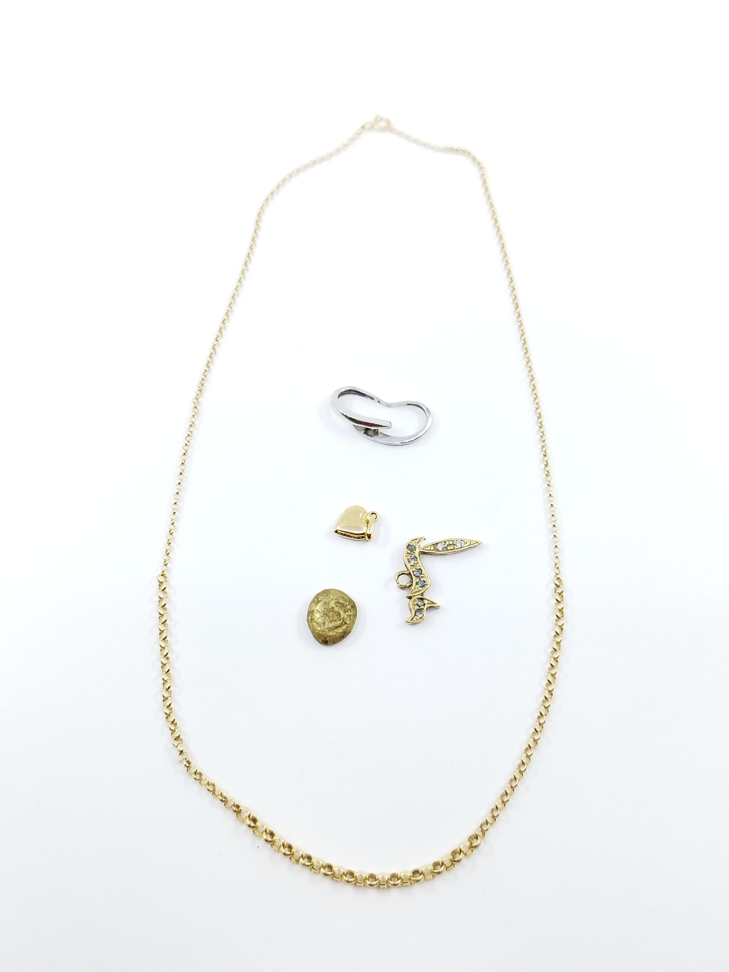 Null 地段包括 :

一条黄金链和一个黄金心形吊坠

一枚750°的黄金佩饰、一枚白金戒指和一枚黄金和白色宝石吊坠

毛重：7,86克