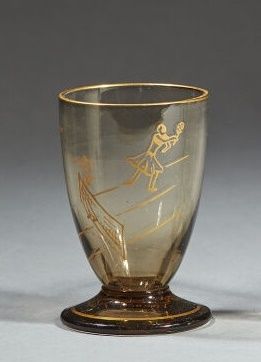 Null 道姆-南希
琥珀色玻璃利口酒杯，颈部和底部有一对网球运动员和金网的金色珐琅装饰。
在脚下签名。
高度：5,6厘米。高度 : 5,6 cm

专家：Ca&hellip;