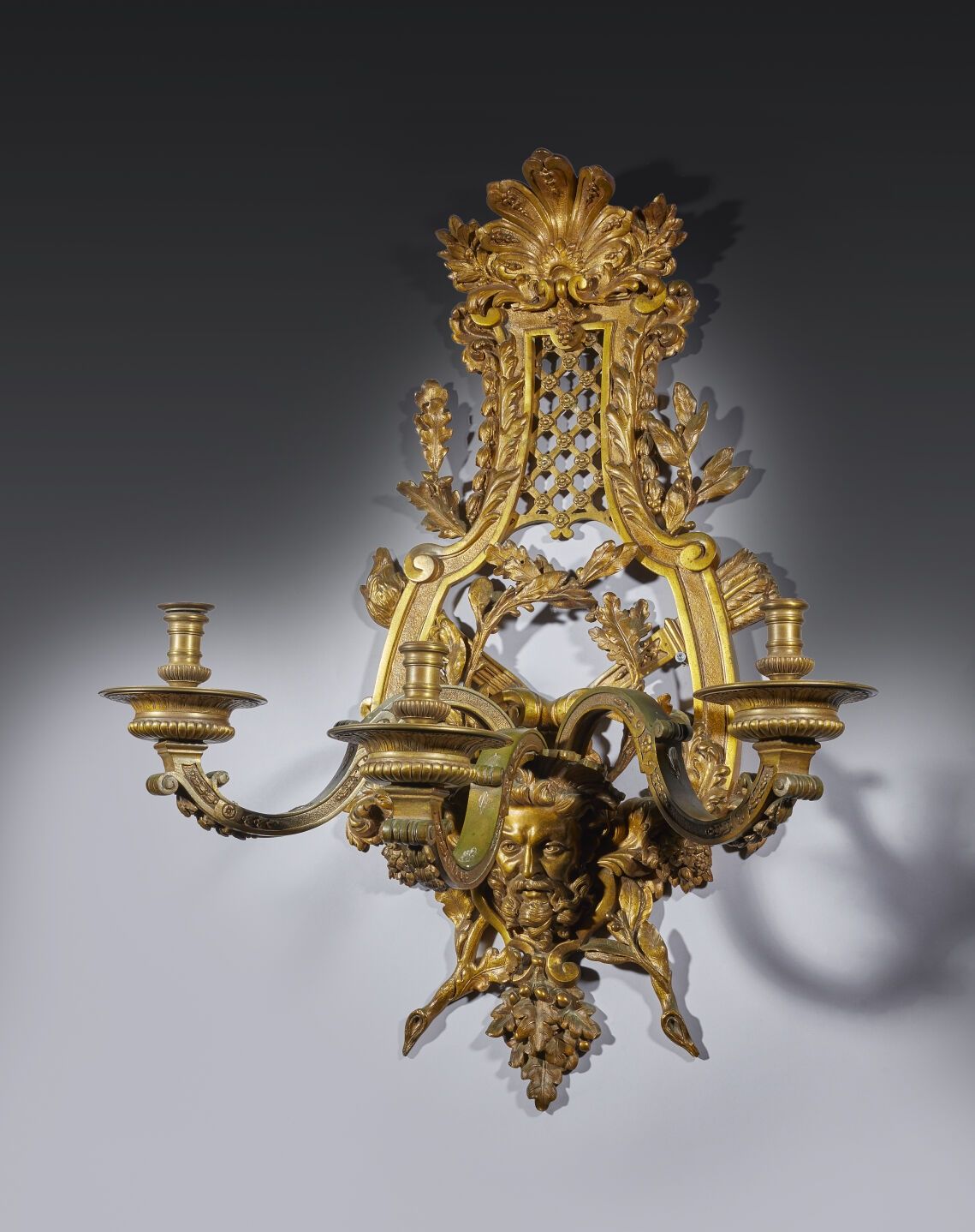 Null 青铜三灯烛台，琴形图案上有棕榈花饰，并饰有橡树叶和老人面具。
19 世纪，安德烈-查尔斯-布尔风格。
高81 厘米；宽：63 厘米