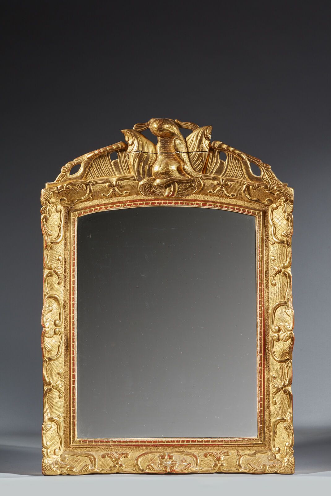 Null 镀金木镜，带风格化叶片装饰
十八世纪
(重新镀金，玻璃已更换，檐口有裂缝）。
高71 厘米；宽：52 厘米
