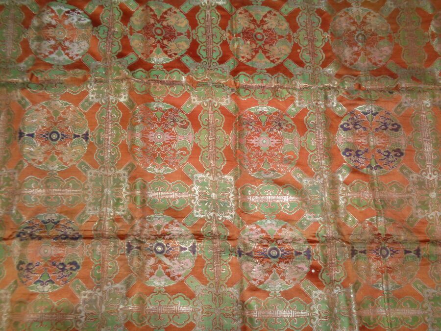 Null 锦缎，日本，约 1800 年
橘色缎底，蓝色、绿色和银色丝绸装饰，花网中的圆形火焰珍珠，衬里。
米数：5.55 米，三条镶板（185 x 189 厘米&hellip;