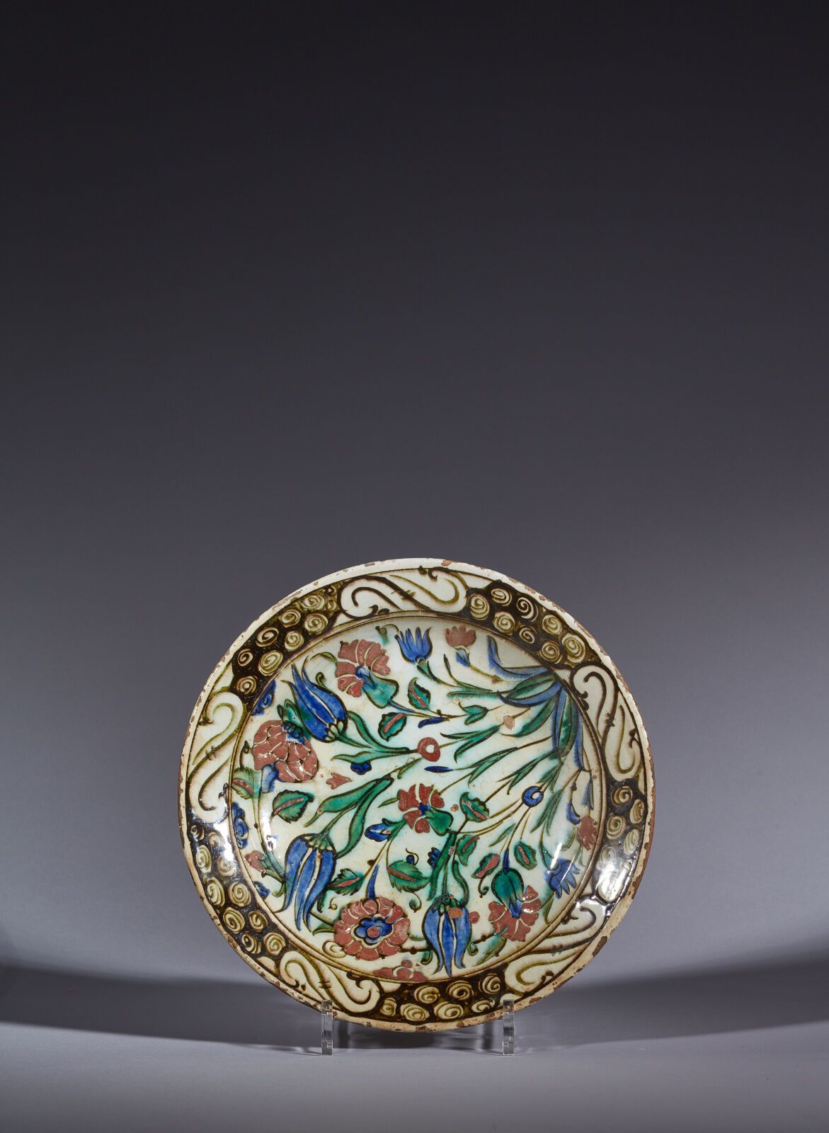 Null 奥斯曼土耳其，伊兹尼克，17 世纪
花饰盘
带有多色彩绘装饰的硅质陶瓷小盘。中央是密集的 "四朵花"，黑色边框上的波浪和岩石组成五个造型 "S"。蓝色&hellip;