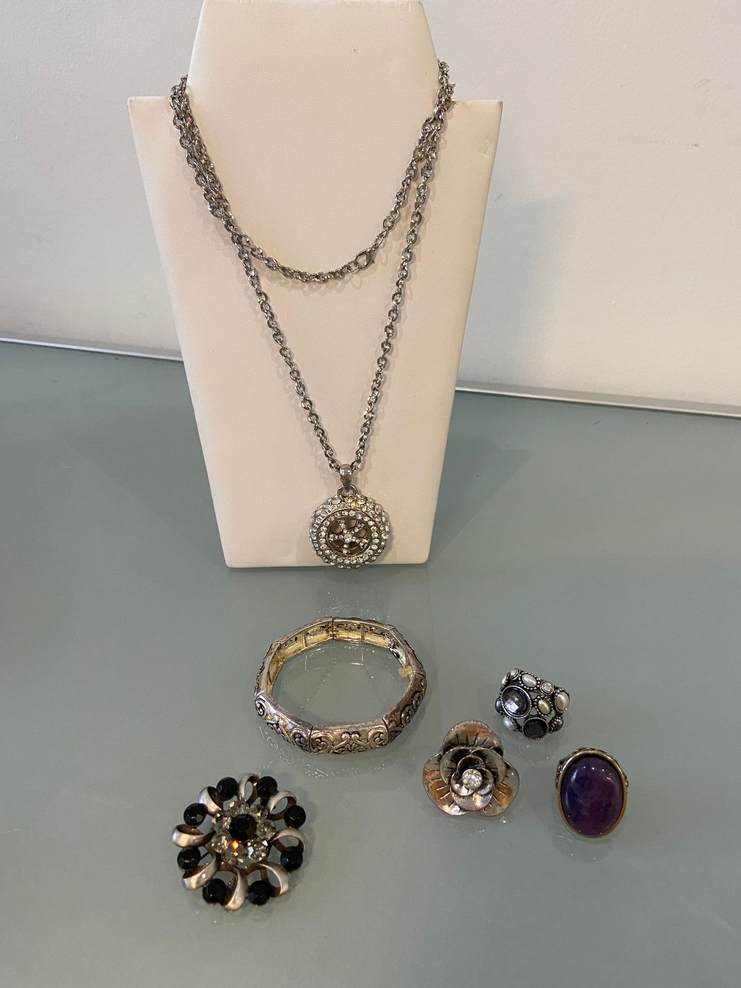 BIJOUX FANTAISIE 一批镀银的服装首饰，包括：三个戒指，一个手镯，一个带车轮吊坠的链条和一个胸针。