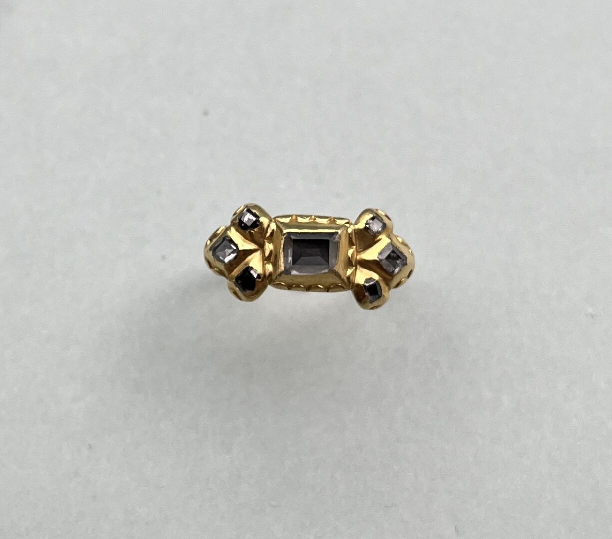 Null 黄金戒指（千分之七十五），凿有卷轴装饰，中心是一颗长方形的玫瑰式切割钻石，周围是较小的钻石，装在卵石上。

作品XIX°。

TDD : 53

毛重&hellip;
