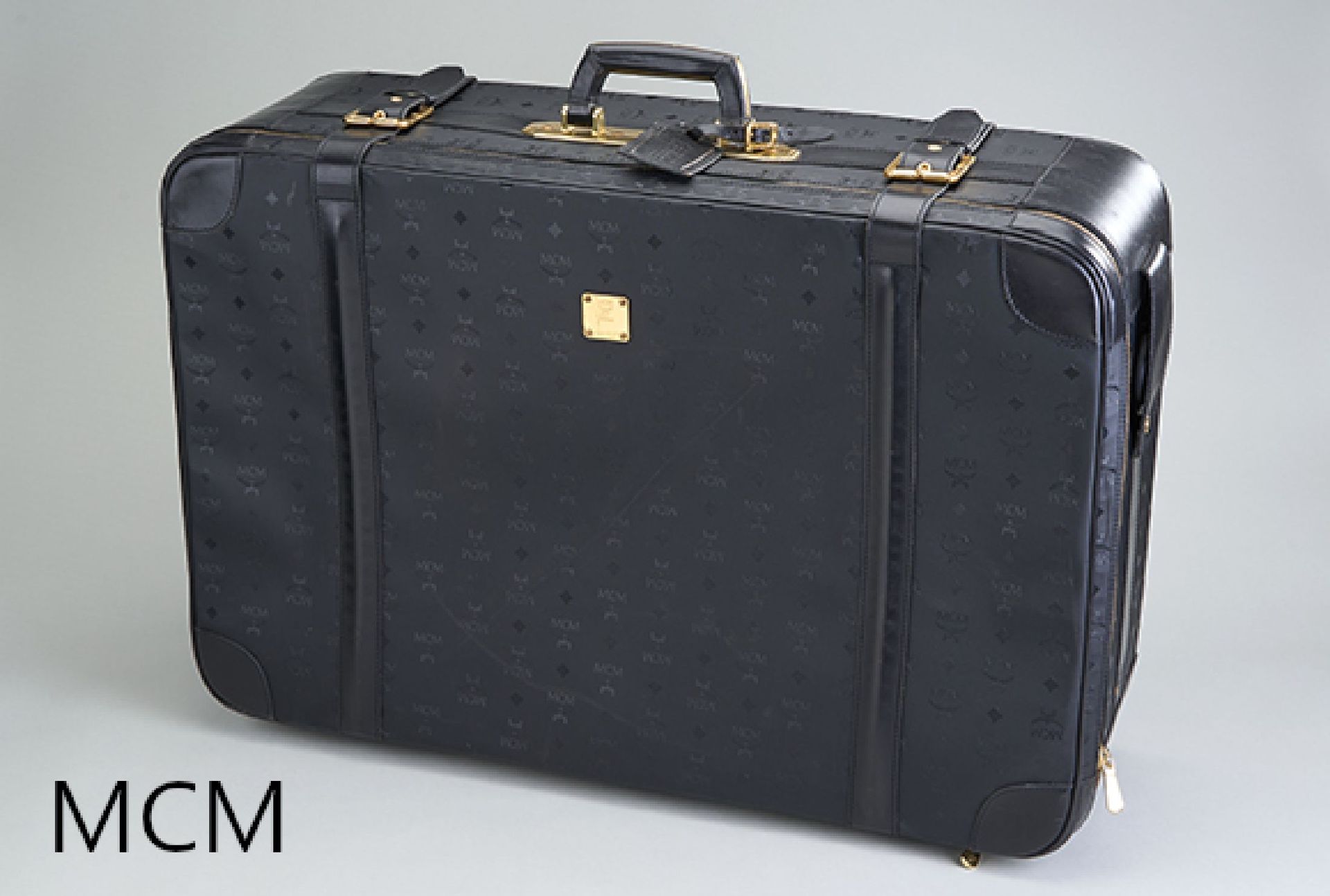 Null MCM 手提箱，黑色 Monogram 帆布，4 个脚轮，镀金金属配件，内衬黑色织物，地址标签，约 75 x 50 x 23 厘米，有较强磨损痕迹