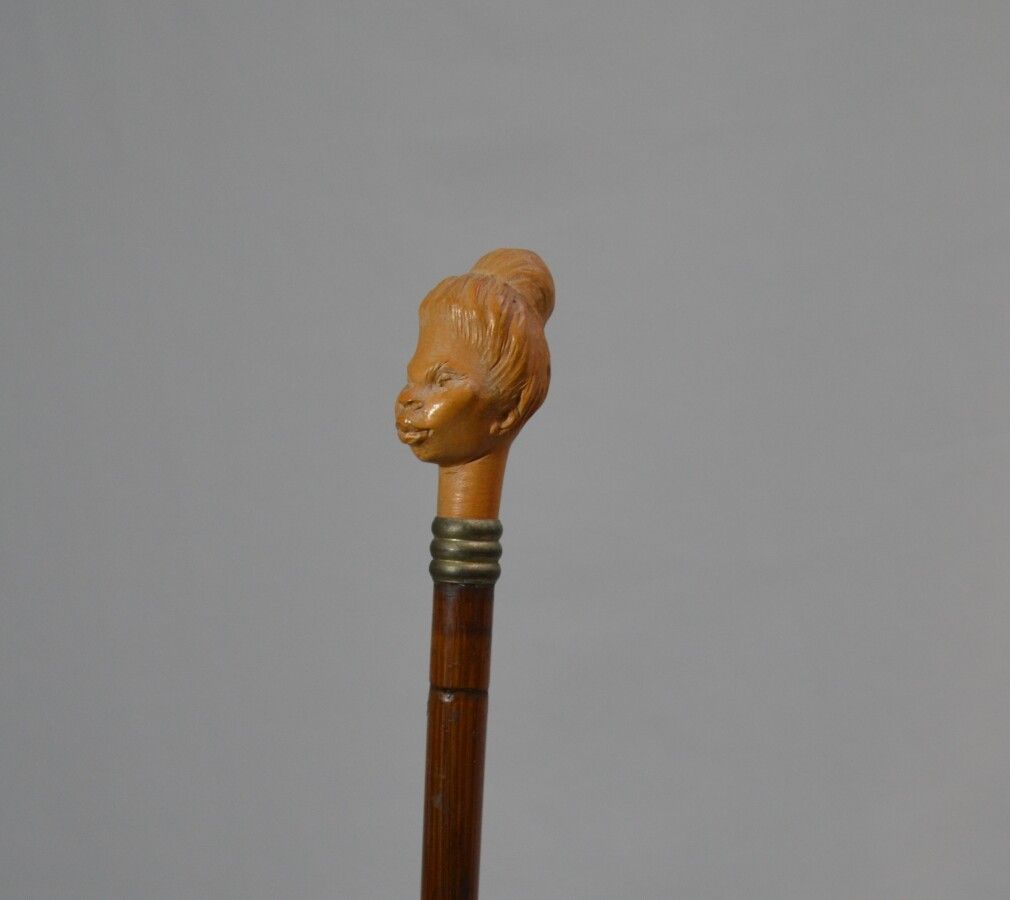 Null 木制手杖，上面有一个雕刻的木制旋钮，显示出一个带发髻的女士的头部

长：88厘米