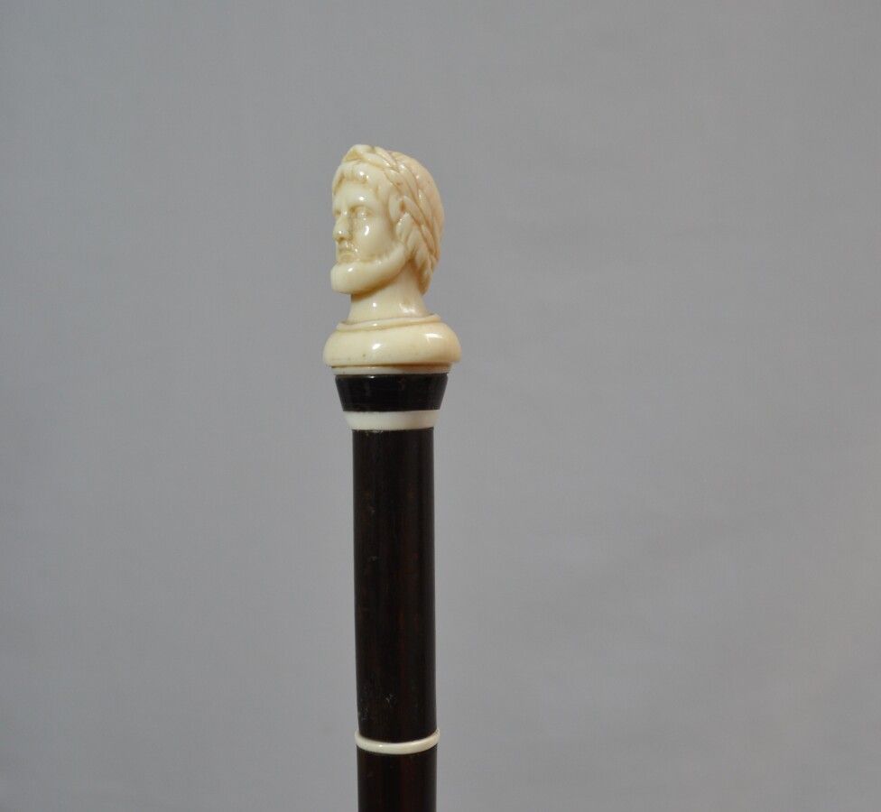 Null 发黑的木质手杖，象牙柄上雕刻着一个仿古风格的人物，用象牙镶边

19世纪

长：91厘米 毛重：238克（有轻微裂纹

CITES n°FR21044&hellip;