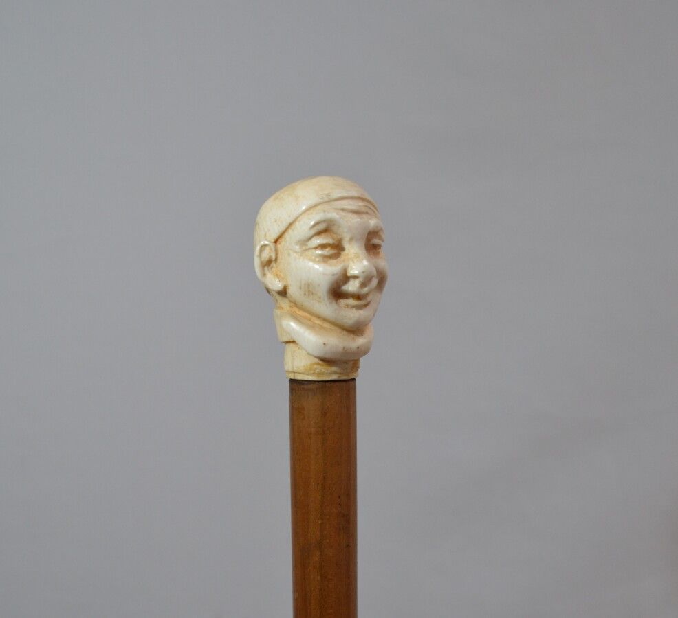 Null Holzstock mit geschnitztem Elfenbeinknauf, der eine lachende Figur zeigt

A&hellip;