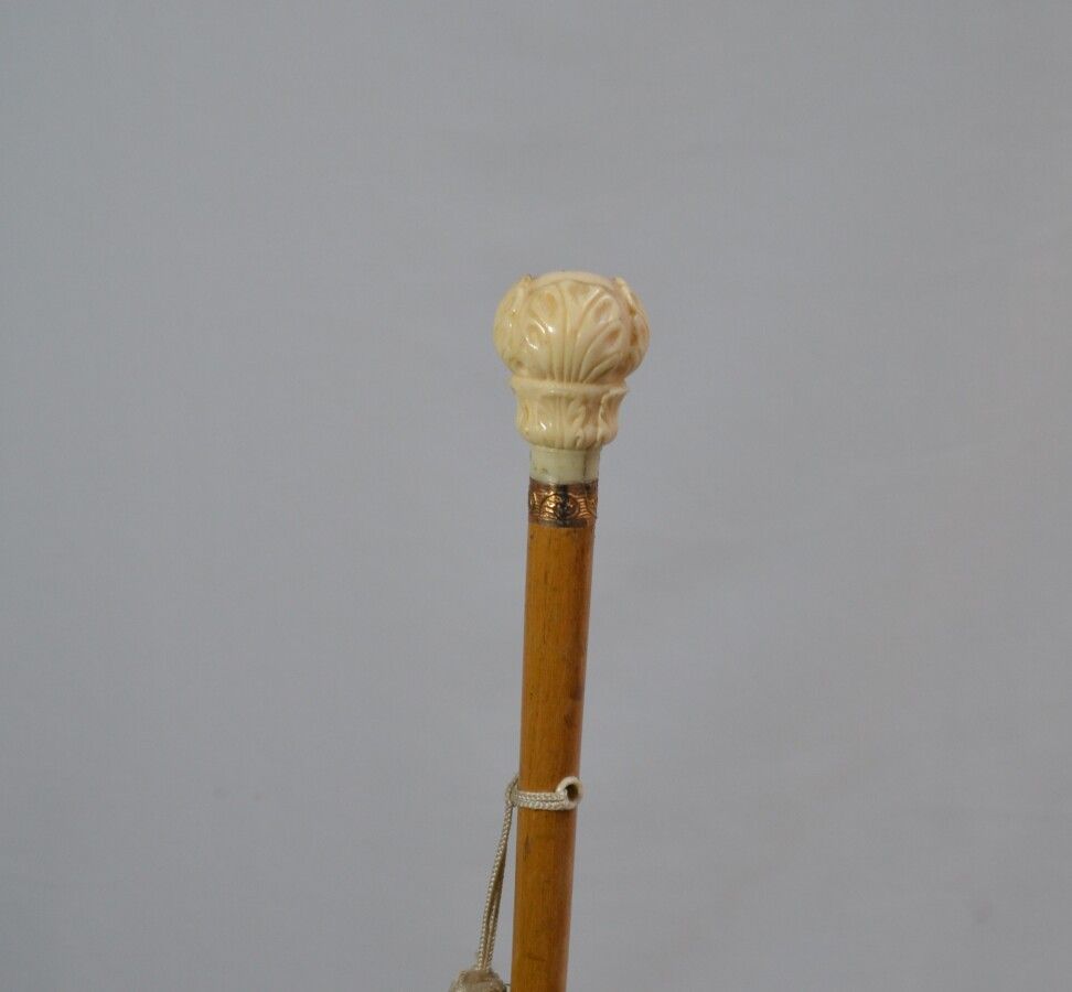 Null 木制手杖，象牙材质的鞍座上雕刻着叶子，框架为镀金金属，带子为织物。

19世纪末-20世纪初

长：92厘米 毛重：138克

CITES n°FR2&hellip;