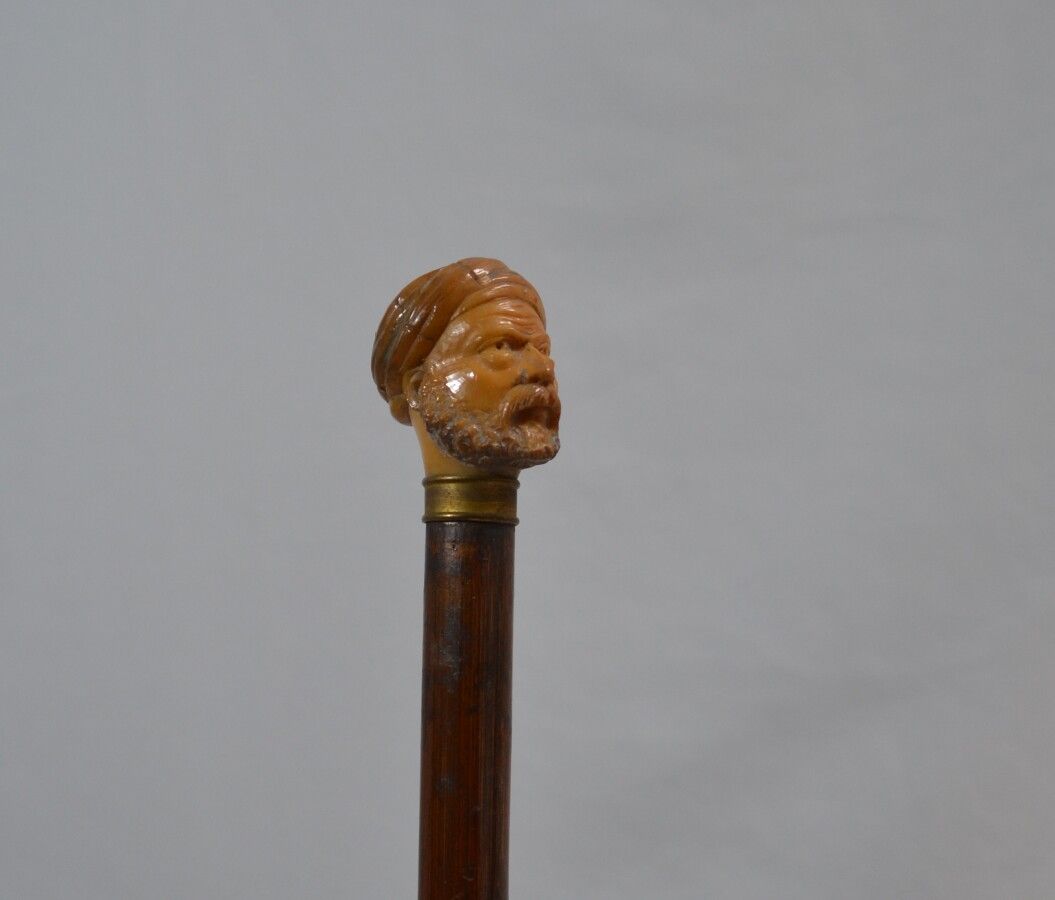 Null CANNE en bois, le pommeau en corne sculpté figurant une tête d'homme au tur&hellip;