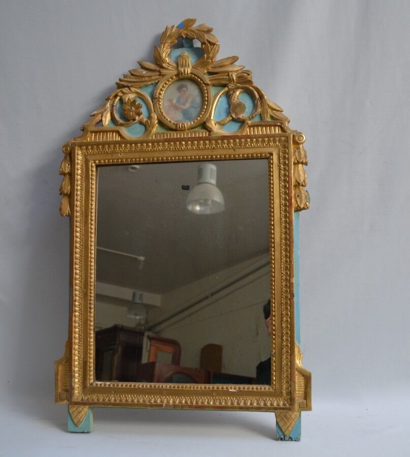 Null 雕刻、上色和镀金的木制镜子，装饰有叶状花纹的奖章

路易十六风格

102 x 61.5 cm (略有意外)