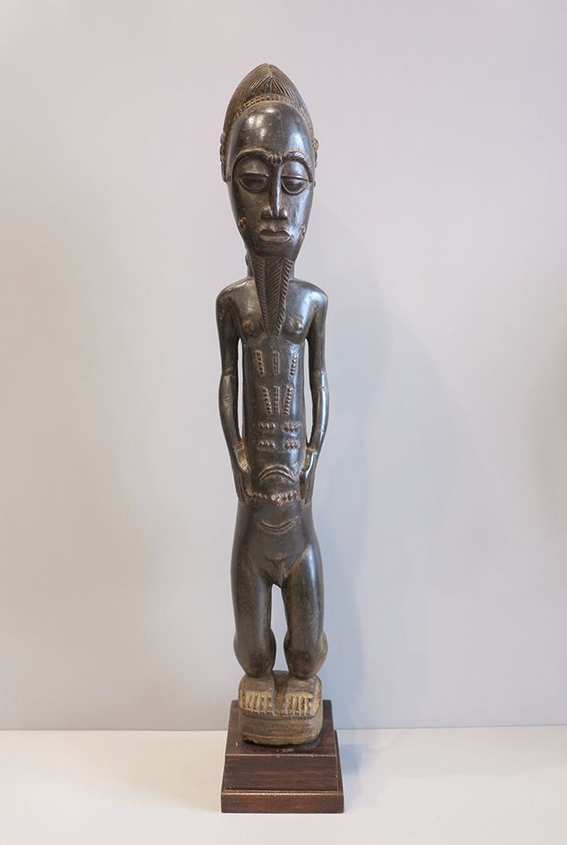 Statue Baoulé 重要的男性雕像，代表一个酋长站在一个小的圆形平台上，他的手臂沿着身体张开，双手放在肚脐两侧。上半身修长，前后有许多特有的疤痕。纹章发&hellip;