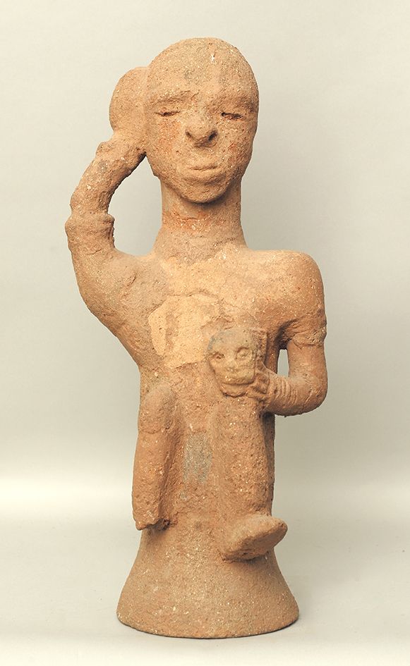 Personnage Katsina 坐着的女性形象，左手握着膝盖上的骷髅头，右手放在头上。

赭色赤土.

非洲，尼日利亚，卡齐纳文化（公元前5年-公元5年
&hellip;