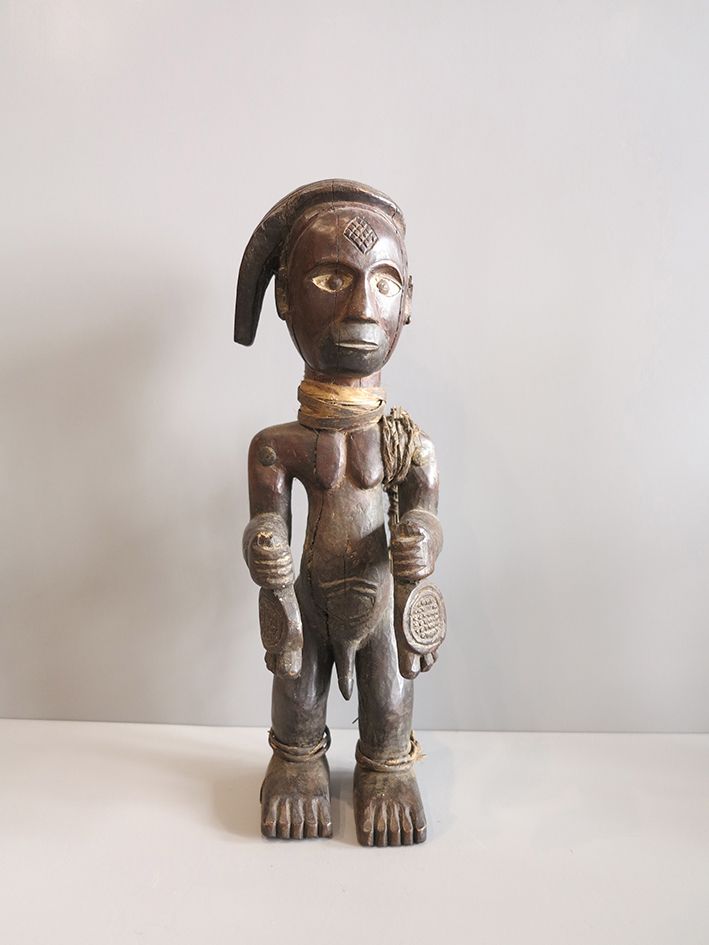 Statue Congo 代表音乐家-戴文的男性雕像。头部有造型和疤痕，高岭土眼睛有铁瞳孔。侧面的头饰有辫子。植物纤维制成的项链。左肩上的箭筒。双手拿着两个铃铛&hellip;