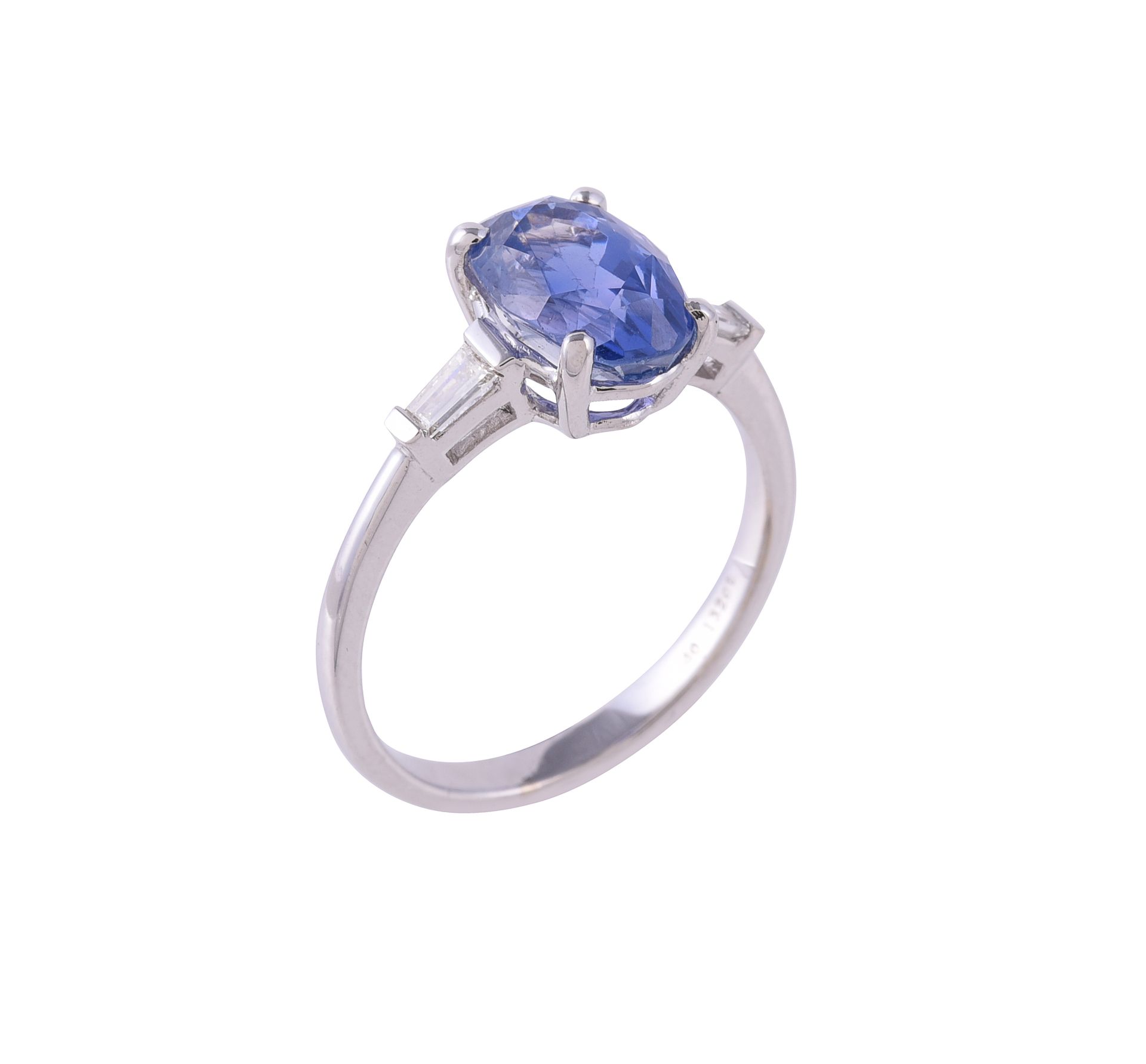 A sapphire and diamond three stone ring 蓝宝石和钻石三石戒指，椭圆形切割的蓝宝石两侧是两颗长方形切割的钻石，印有18K &hellip;