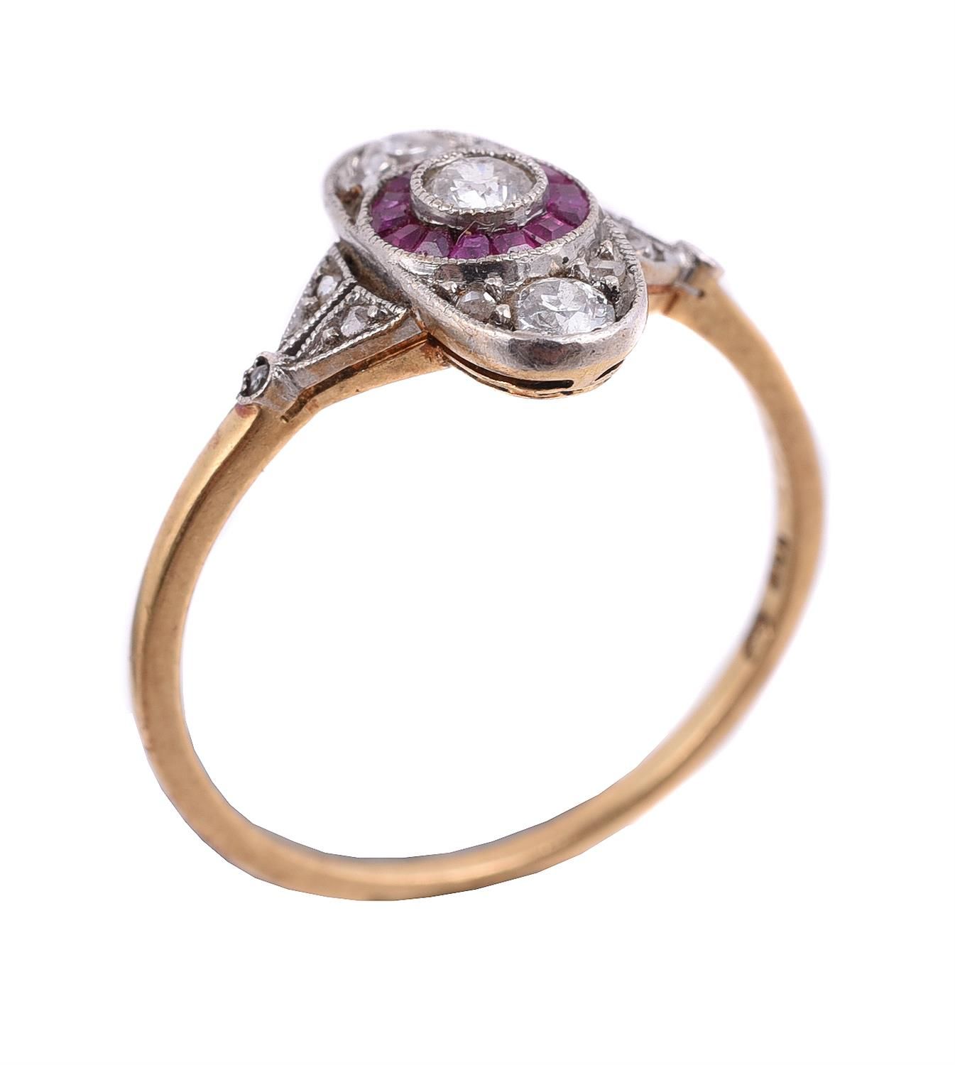 A diamond and ruby panel ring 一枚钻石和红宝石面板戒指，椭圆形面板上有一圈校准切割的红宝石，中心是一颗老式切割的钻石，两端镶嵌着玫&hellip;