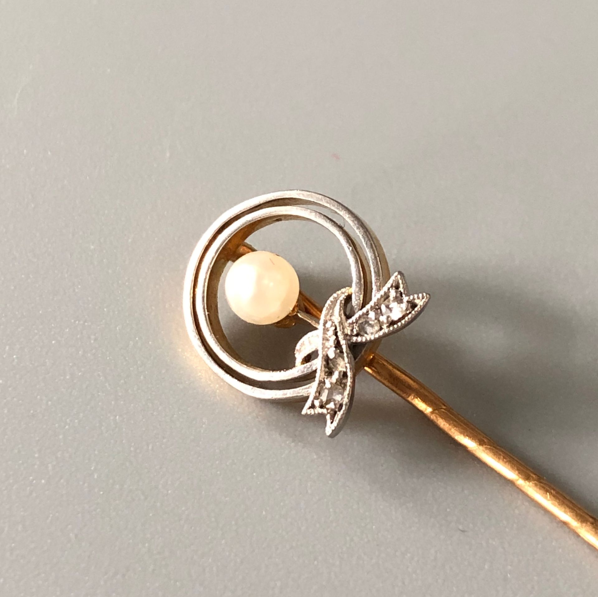 Null 黄金和18K白金（千分之七十五）领带针，上面有一个镂空装饰的结，上面有钻石玫瑰，中间是一颗珍珠，可能是精品。毛重：2,2克。珍珠的直径：3.5厘米。图&hellip;
