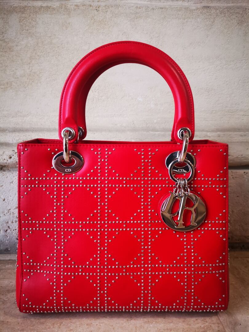 CHRISTIAN DIOR Sac modèle Lady Dior en cuir rouge, le motif cannage clouté. Garn&hellip;