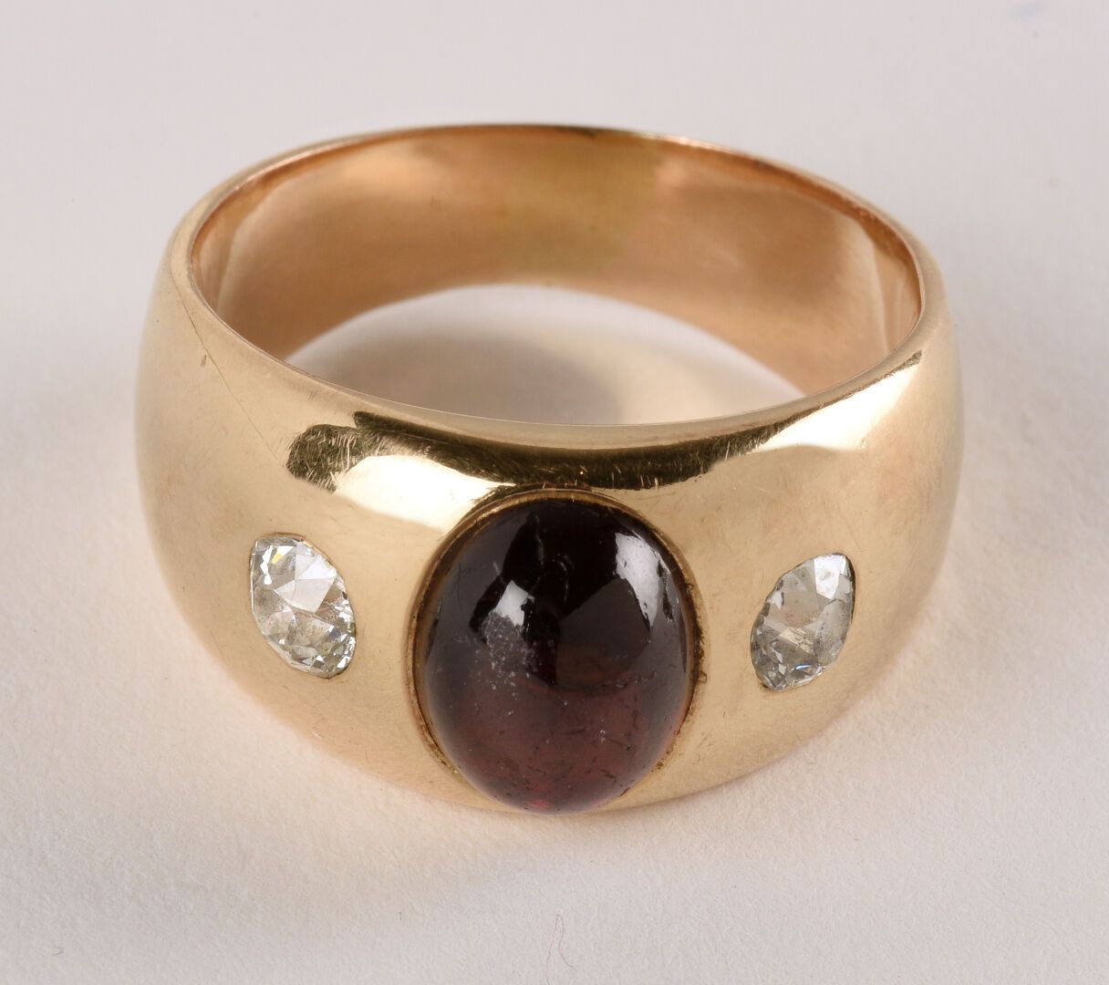 Null 黄金戒指18K（750千分之一），装饰有凸圆形切割的石榴石，由两颗老式钻石支撑。转指：58。

P.毛重：11.9克。