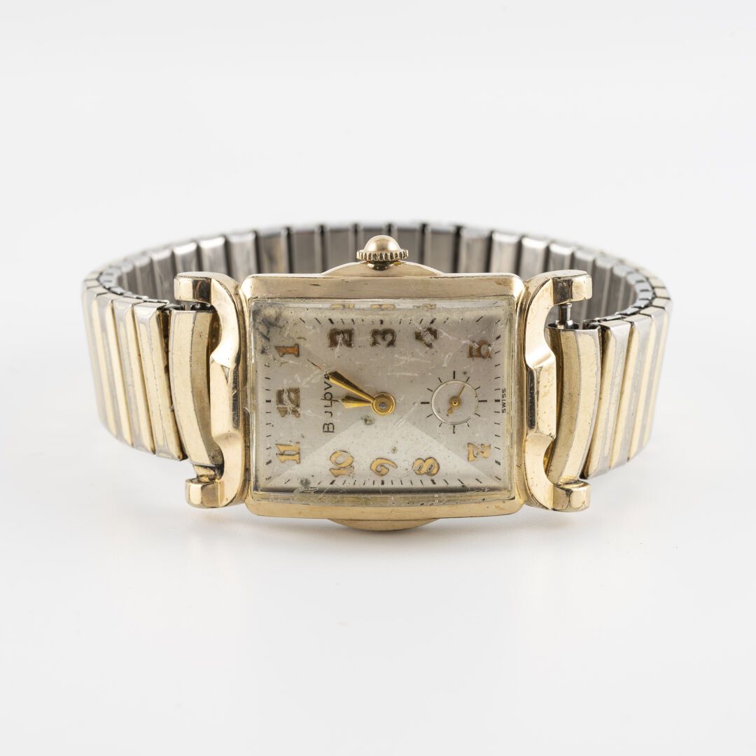 BULOVA vers 1955 电镀金属腕表，风格化的弧形表壳，带倒角，旋入式表冠和夹式表背。

大型凸圆形玻璃。

灰色钻石点表盘，应用金色阿拉伯数字，黑色&hellip;