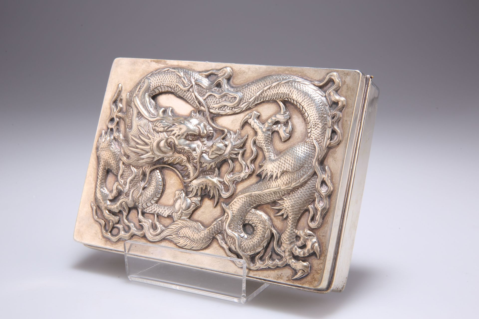 Null 一个大型的中国出口银烟盒，由王兴公司，香港，19世纪末/20世纪初，长方形，铰链盖高浮雕的三爪龙和珍珠。15厘米宽，13.9金衡制盎司70090042&hellip;