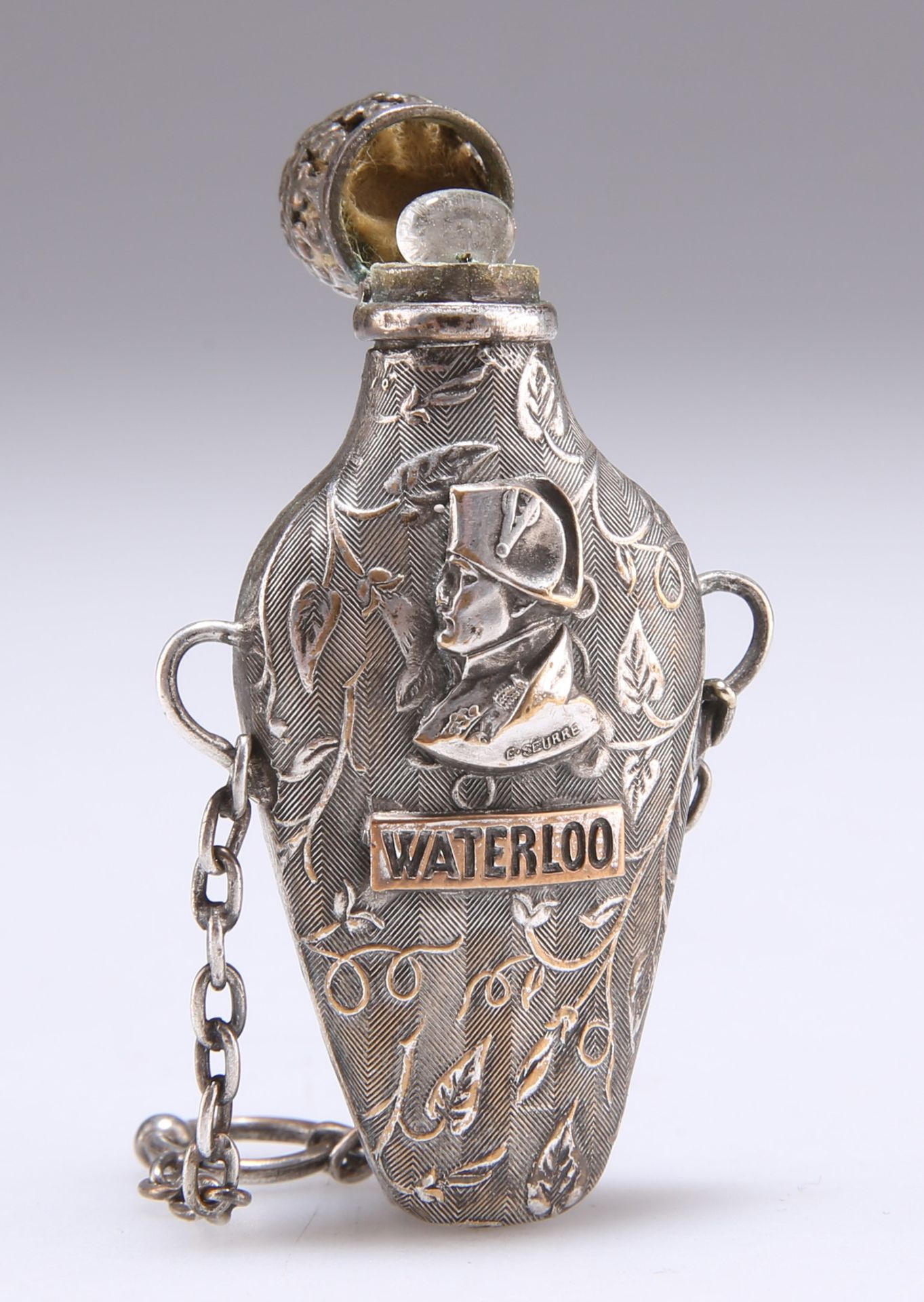 Null 19世纪银镀 "WATERLOO "香水瓶，扁平的卵形瓶身上有拿破仑的半身像，上面有 "WATERLOO "旗帜。高6厘米10015060