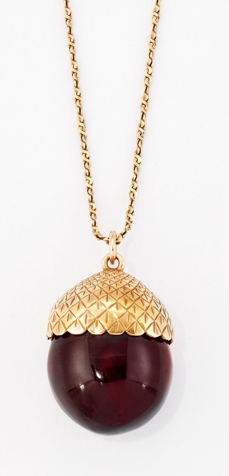Null AN AMBER ACORN PENDANT ON CHAIN, an amber 'acorn' held within an engraved c&hellip;