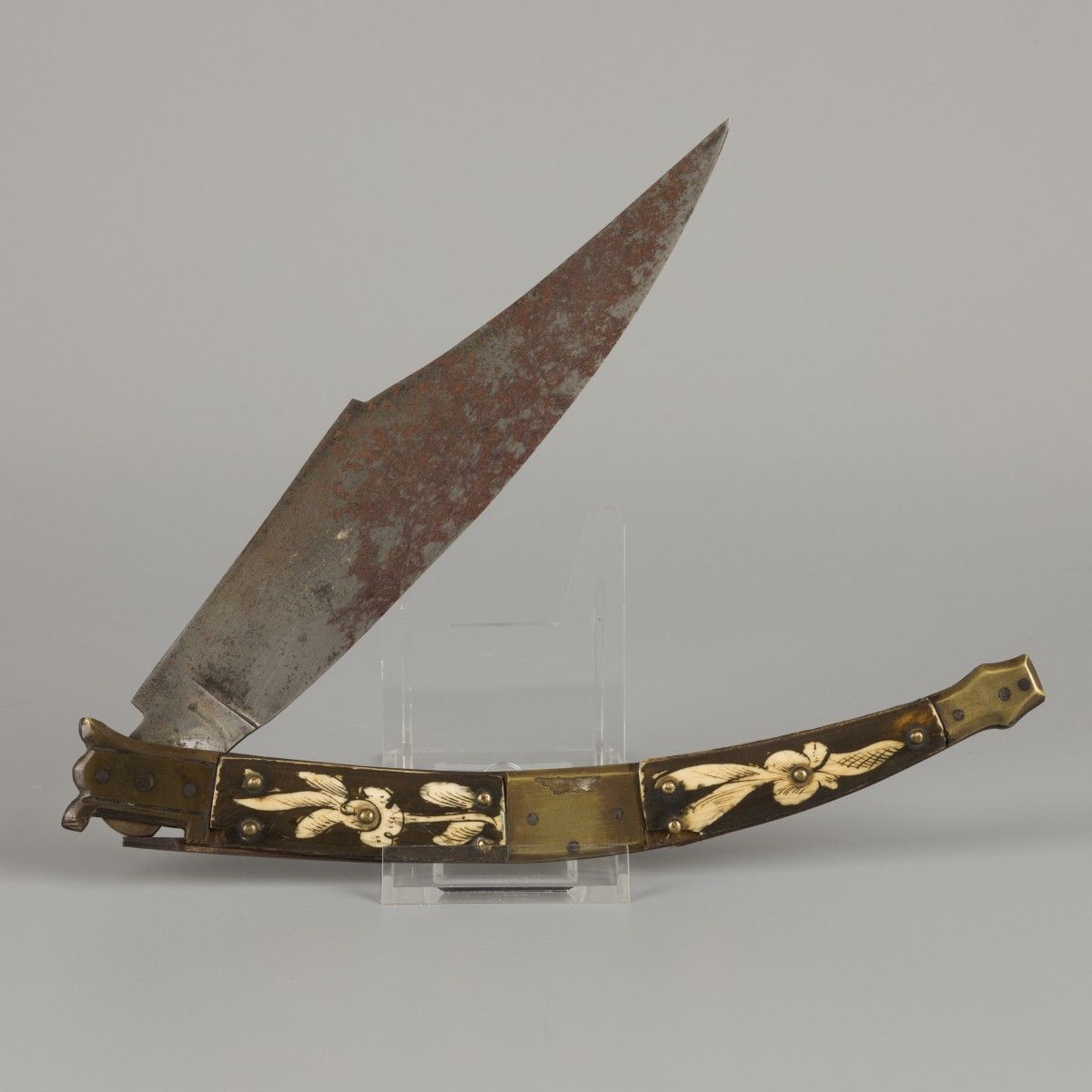 A "Navajo" folding knife, Spain, 19th century. 柄上有铜和骨，骨上有花的图案。测量。长：24.1厘米。估计：60 &hellip;
