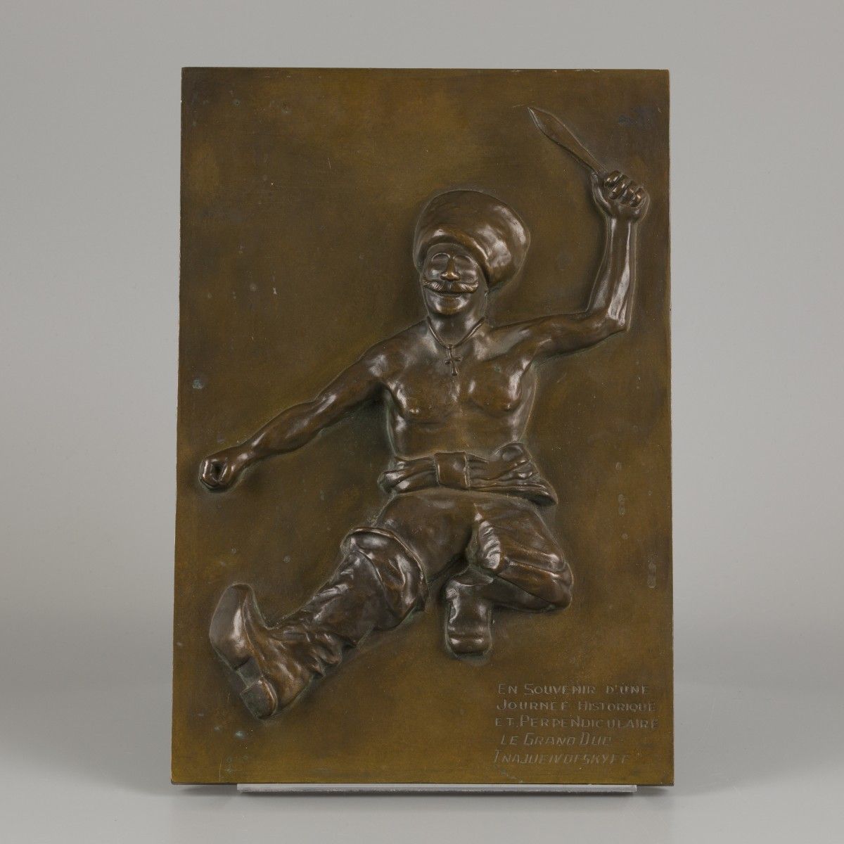 A bronze plaquette of a dancing Cossack. Beschriftet: "En souvenir d'unne / Jour&hellip;