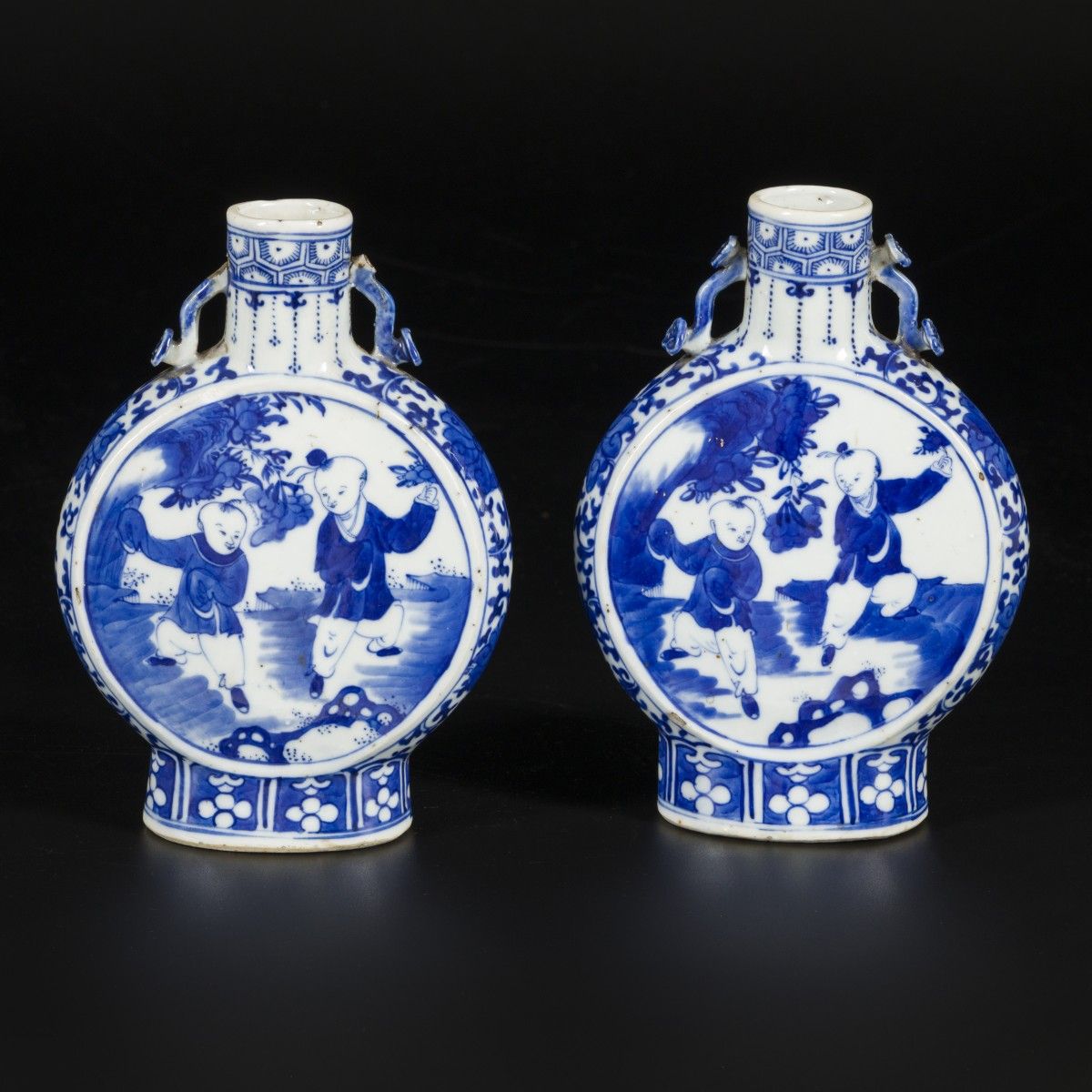 A set of (2) porcelain moonbottles decorated with playing "zotjes", marked Kangx&hellip;