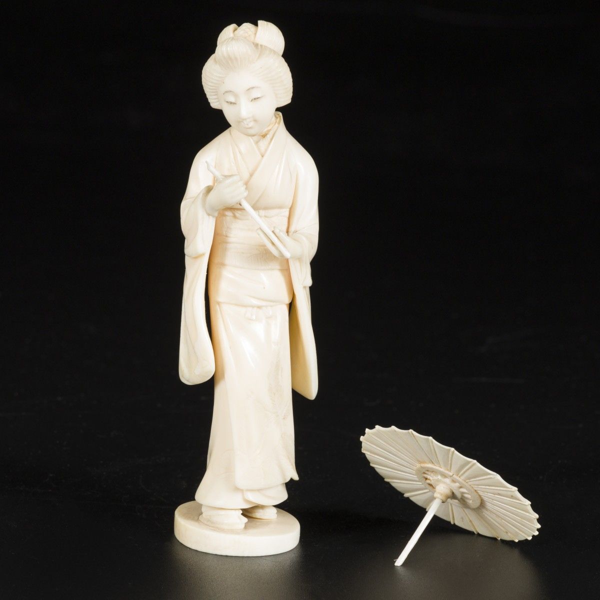 An ivory sculpture in the shape of a dame with an umbrella. Japan, late Meji per&hellip;