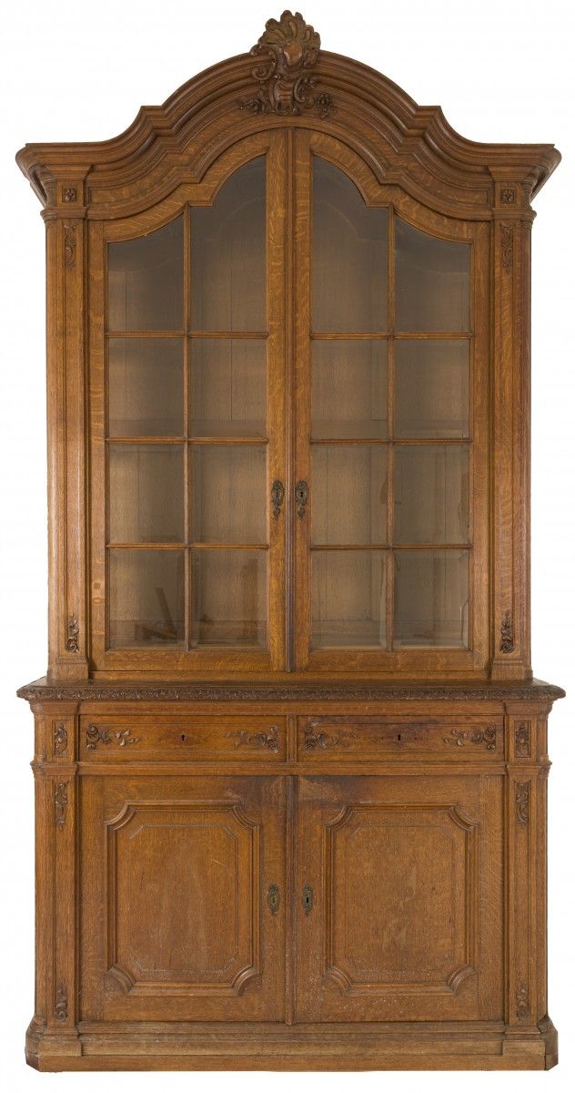 An oakwood 'Liège' cabinet, Belgium, 19th century. 拱形的檐口上有雕刻的徽章，上面有两扇玻璃门，边上有两个抽屉&hellip;