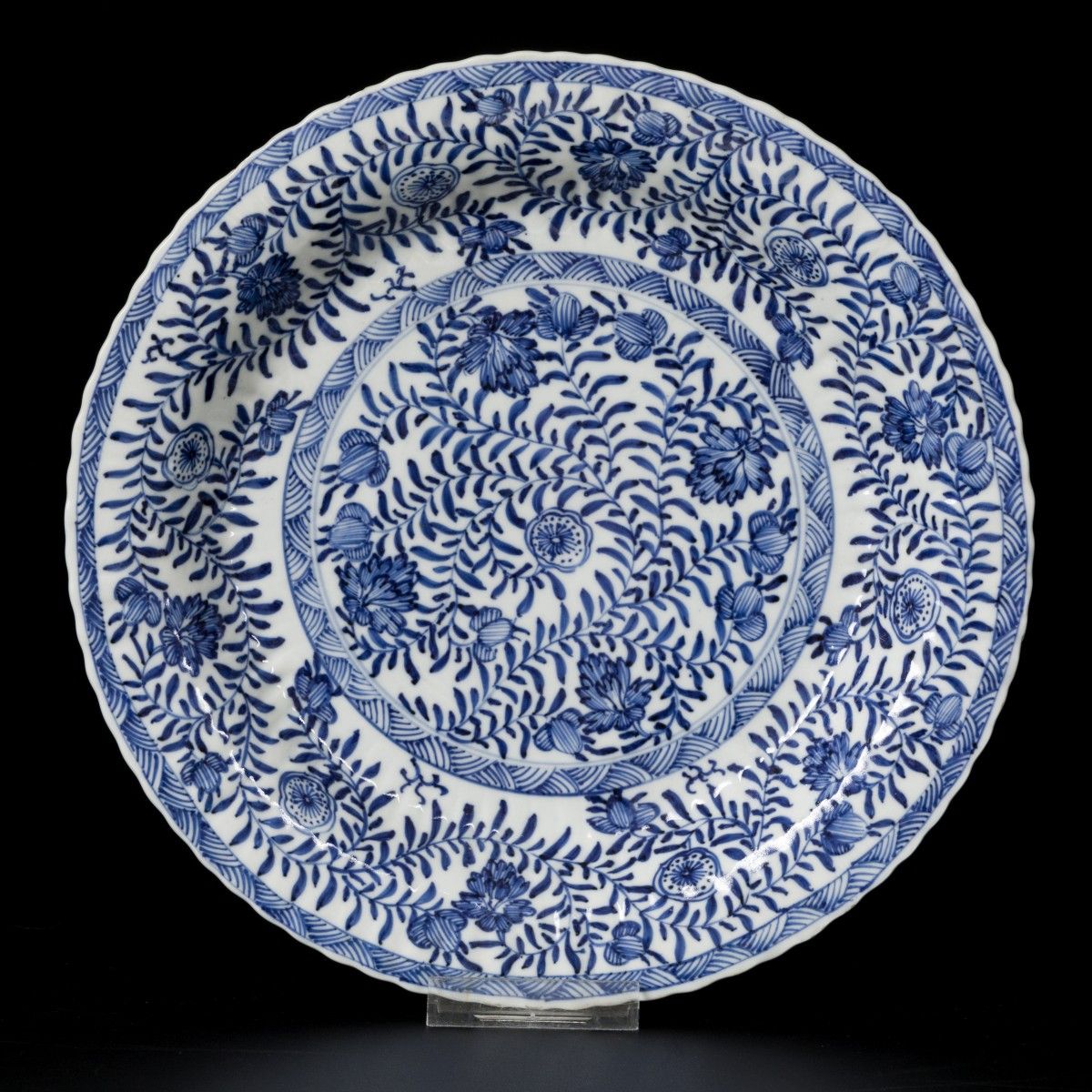A porcelain ribbed charger with floral decoration, China, Kangxi. 直径27厘米。缺口和斑点。估&hellip;