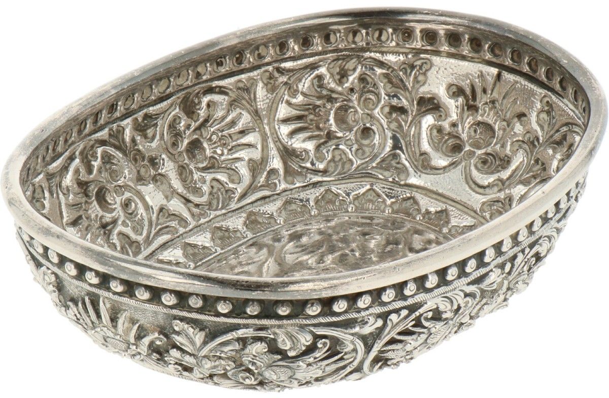 Delicacy-charger silver. 椭圆形的模型上点缀着传统的repoussé图案。印度尼西亚，20世纪，有标记。ZI - 有轻微的老化和使用痕迹&hellip;