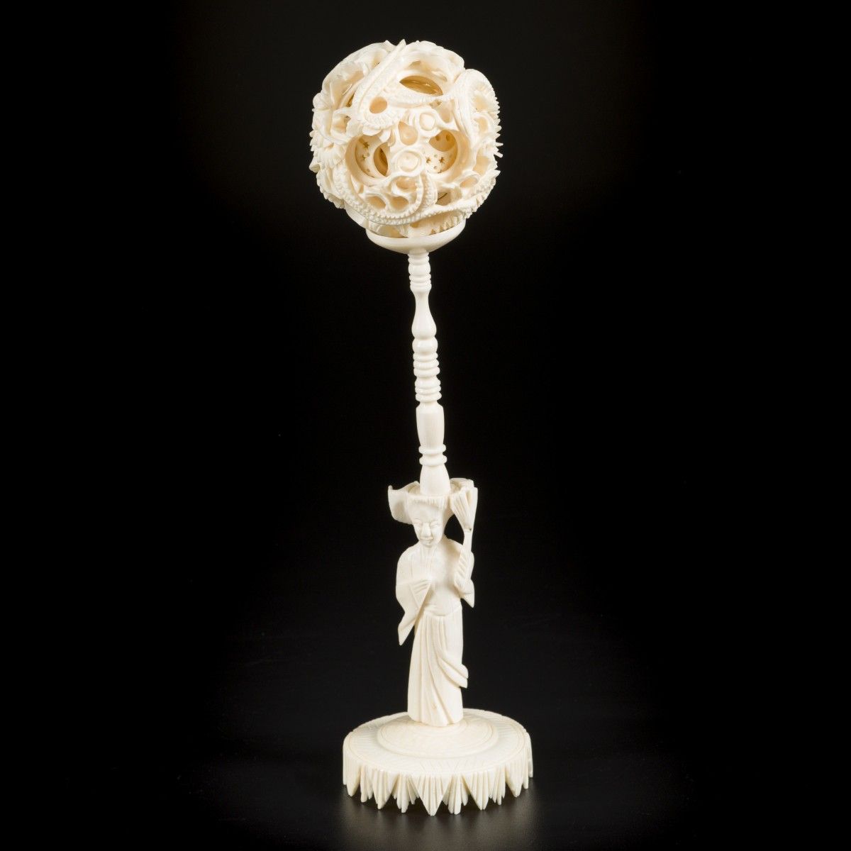 An ivory puzzle ball on ivory stand. China, circa 1920. H. 21 cm.