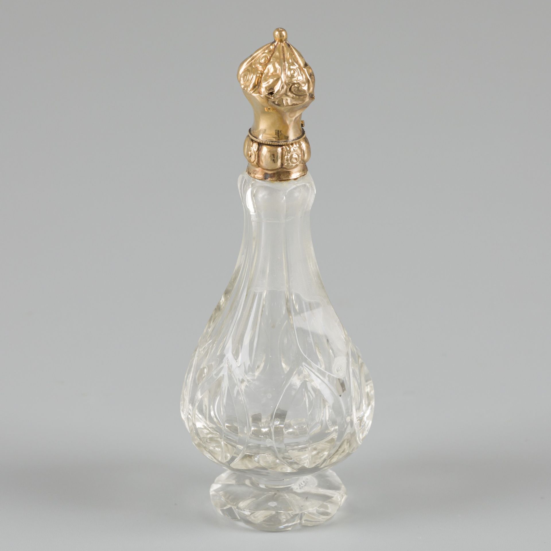 Perfume bottle gold. 切割的水晶玻璃瓶，金色的瓶盖上有浮雕的装饰，并配有原来的玻璃瓶塞。荷兰，19世纪末/20世纪初，印记：橡树叶-有磨损和&hellip;
