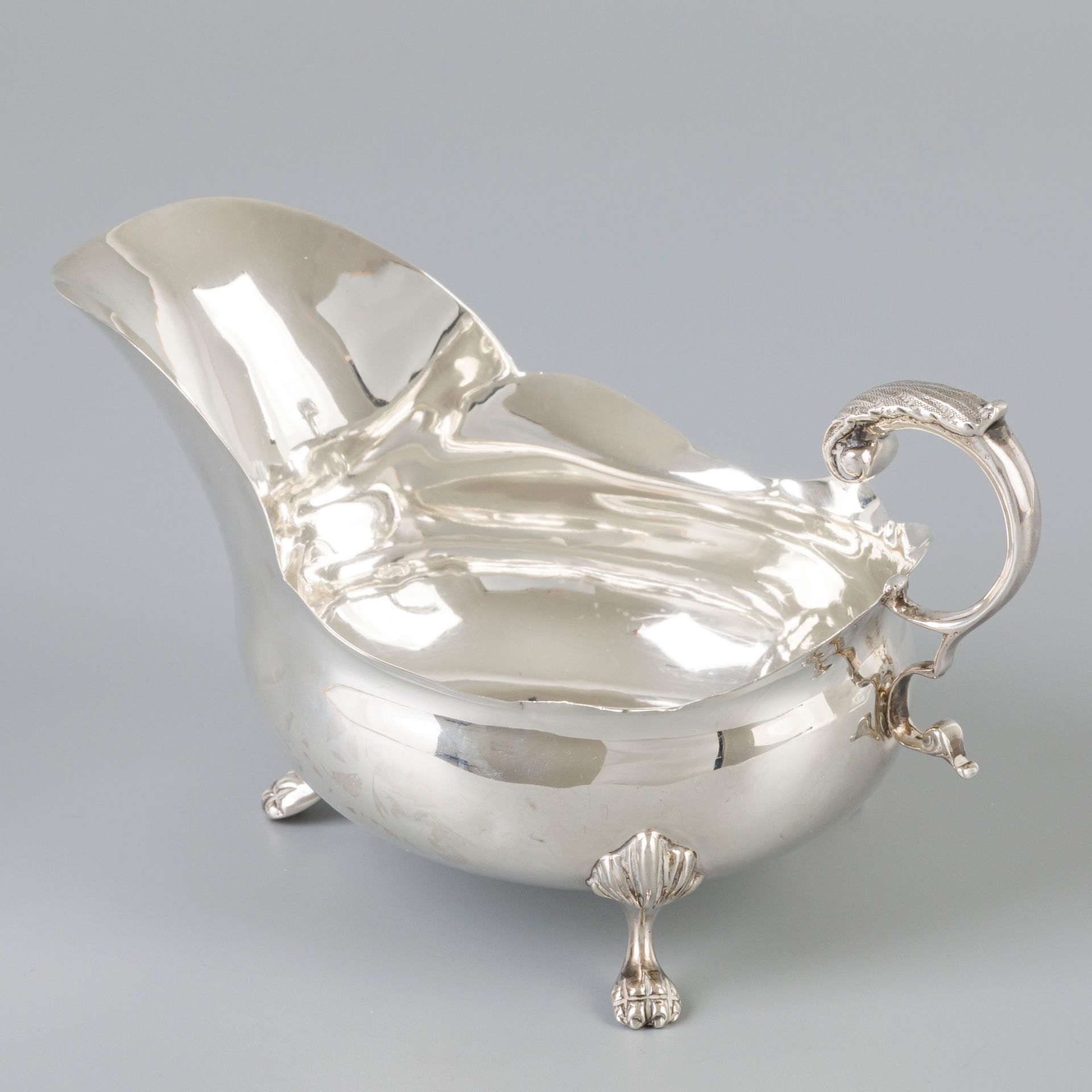 Sauce boat silver. 模型有扇形边缘，焊接的风格化手柄和三个焊接的爪子脚。英国，伯明翰，Jones & Crompton，1905年，印记：狮子&hellip;