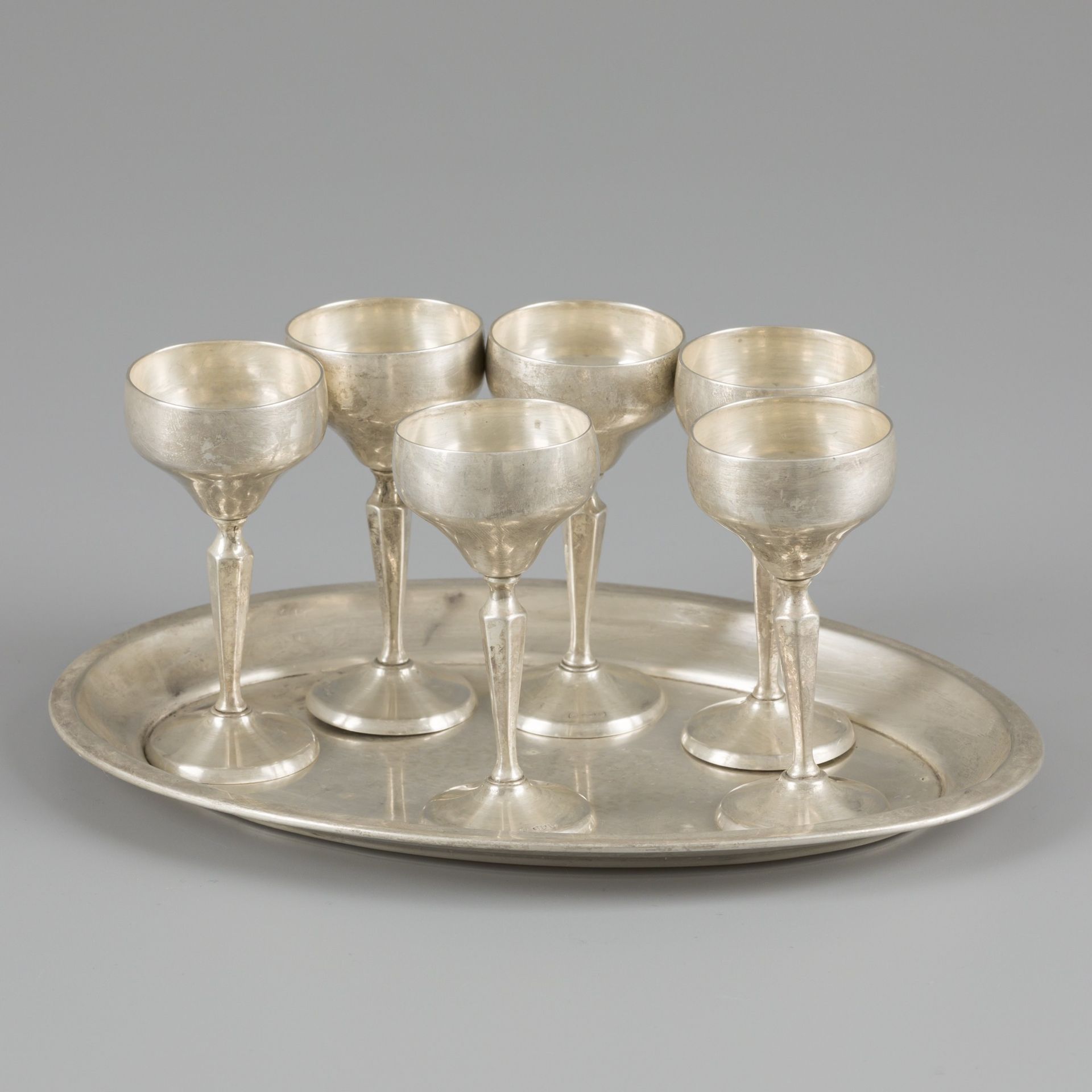 Serving tray with silver glasses. 椭圆形托盘，有折边，有6个配套的银质饮杯。德国，普福尔茨海姆，卢茨和魏斯，20世纪，标志：月&hellip;