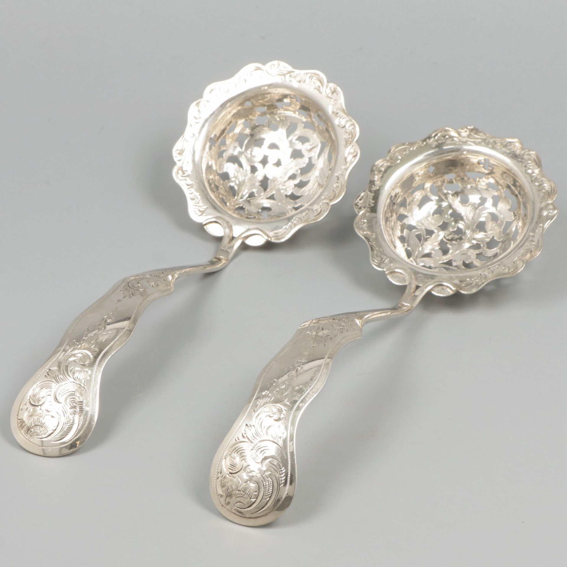 2-piece set of silver sifter spoons. 美丽的套装，刻有罗卡莱斯和棕榈叶的装饰。荷兰，1860年，印记：狮子，密涅瓦，不清楚的&hellip;