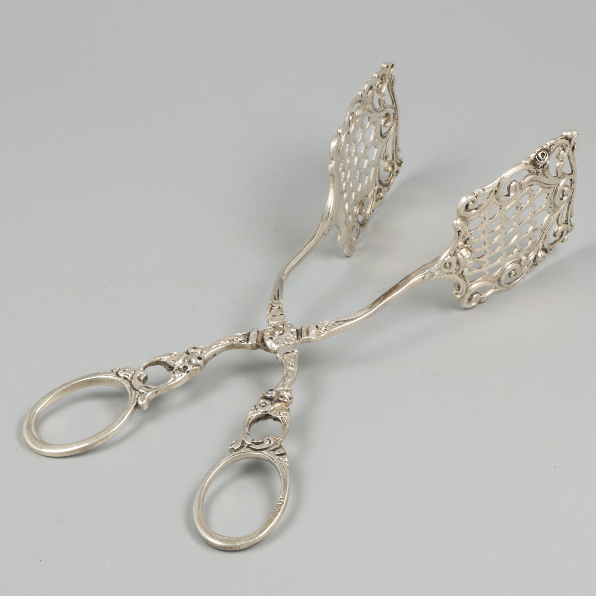 Biscuit tongs silver. Model with molded decorations and partly openwork pegs. Ge&hellip;