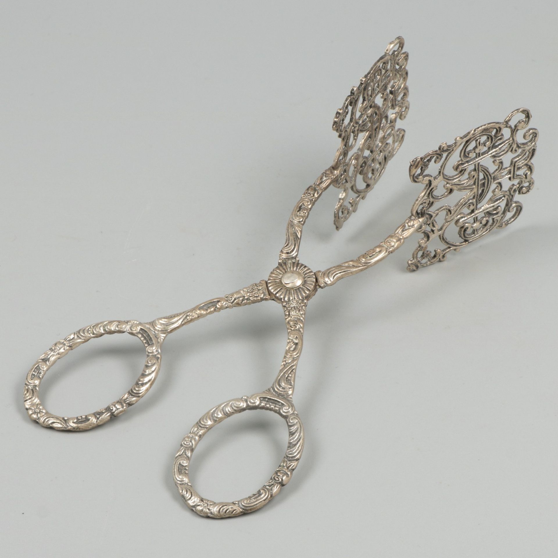 Biscuit tongs silver. Model with molded decorations and partly openwork pegs. 20&hellip;