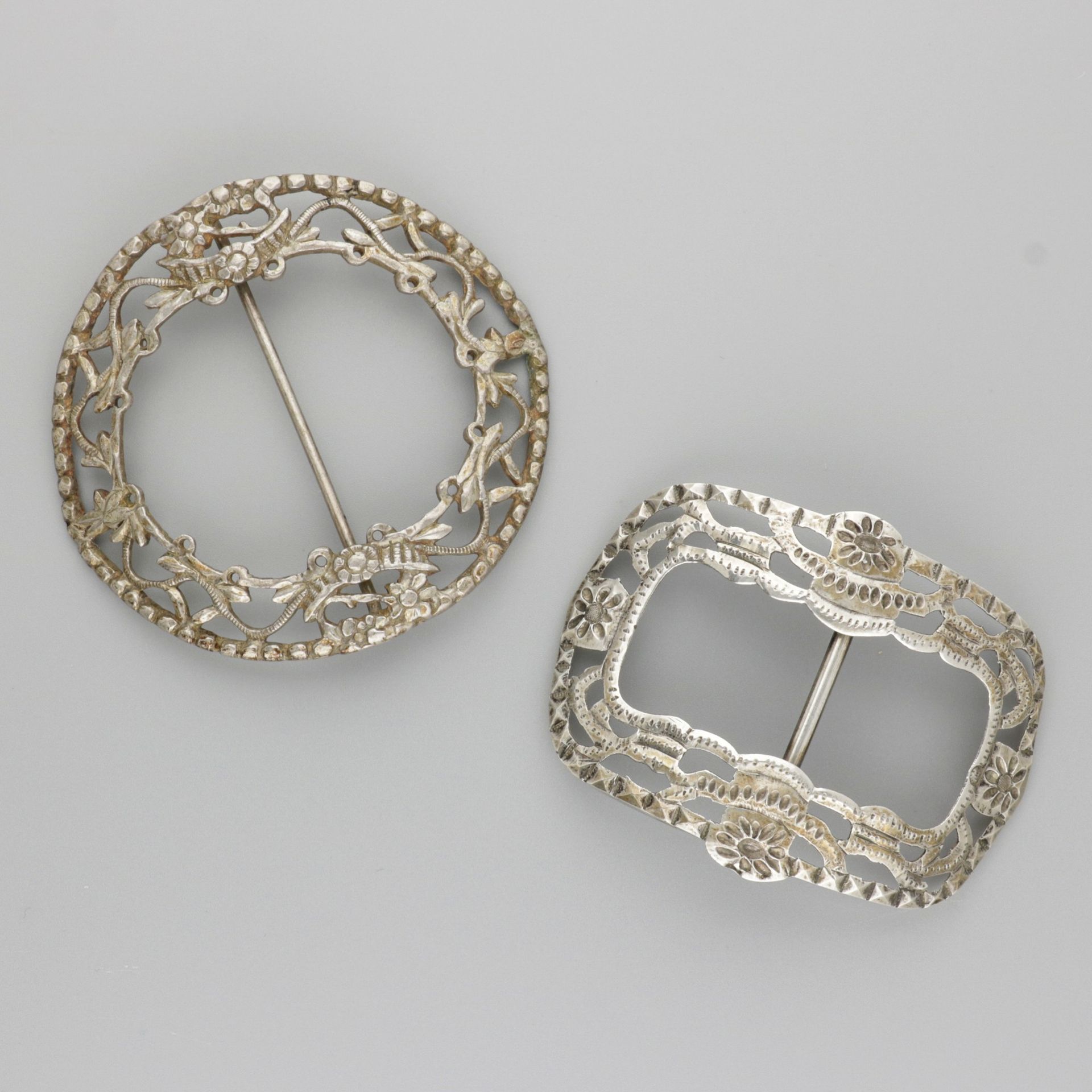 2-piece lot buckles silver. 圆形和长方形的模型，有模制的装饰。都是弯曲的。荷兰，19世纪末/20世纪初，印记：各种印记--磨损痕迹。&hellip;