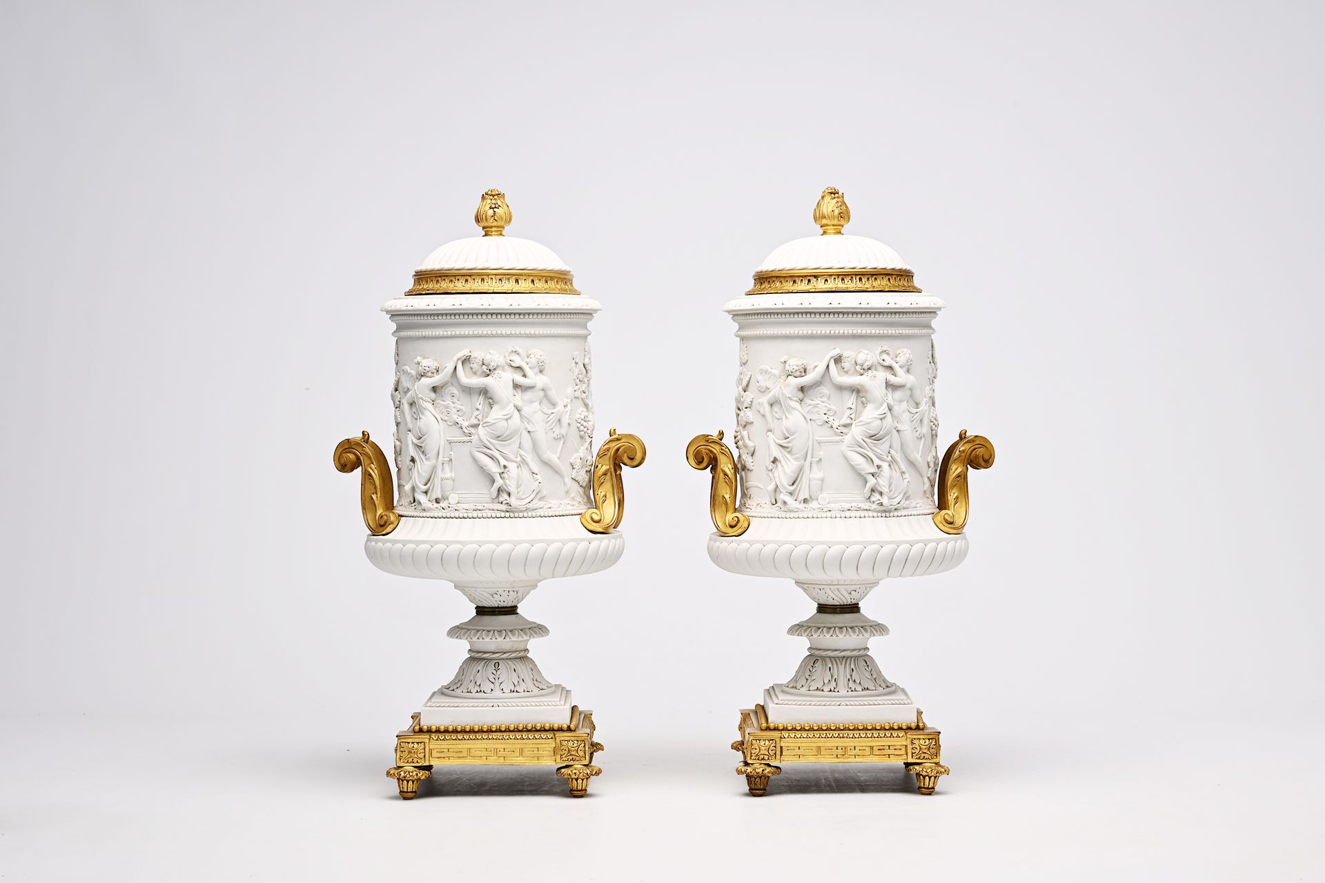 A pair of French biscuit gilt bronze mounted vases and covers with a frieze with&hellip;