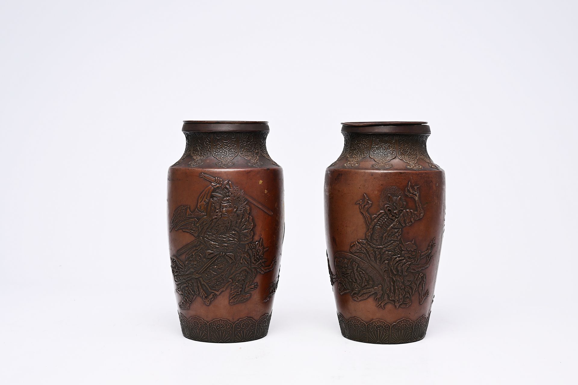 A pair of Japanese bronze vases with relief design of demons in a landscape, Mei&hellip;