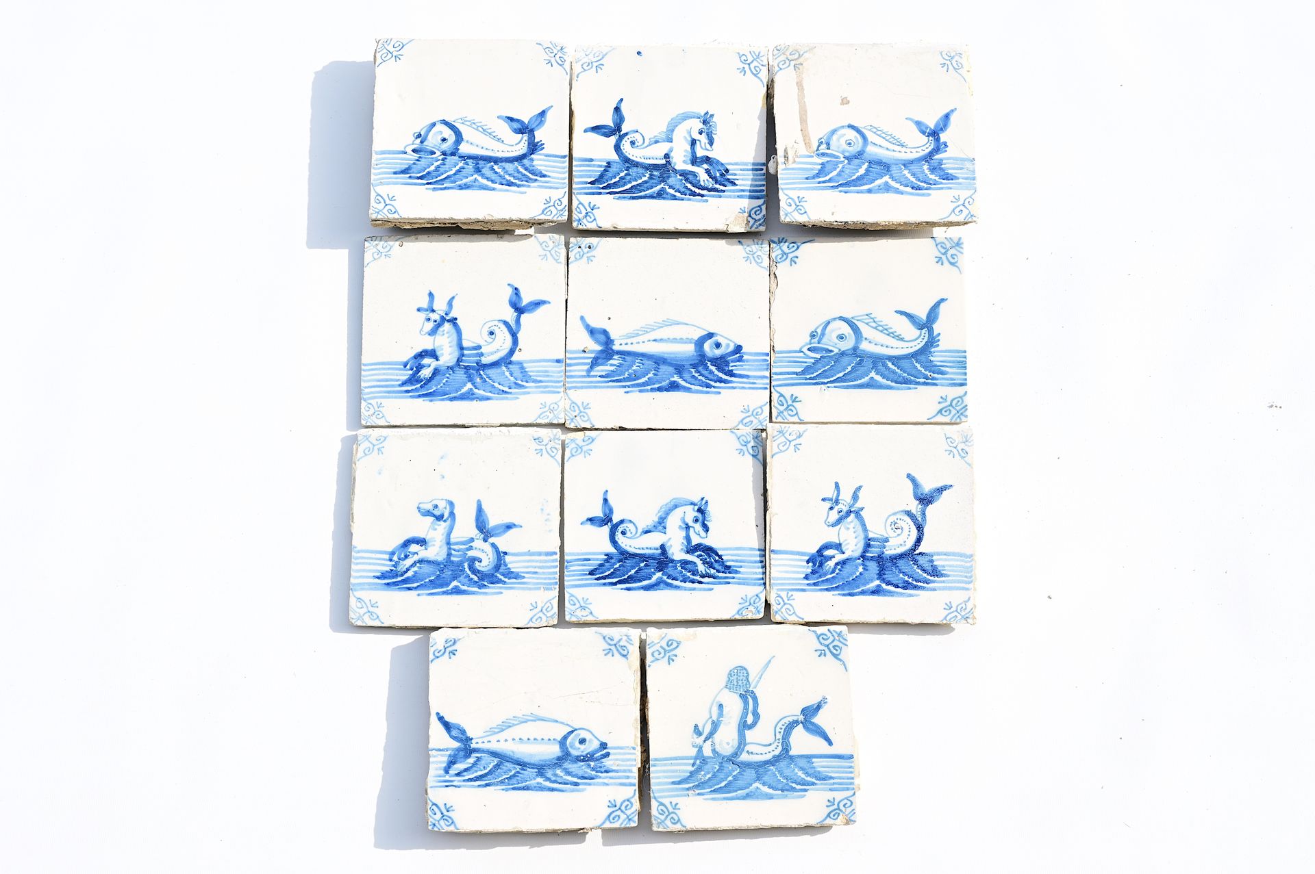 Eleven Dutch Delft blue and white 'sea monster' tiles, 19th C. Onze carreaux de &hellip;