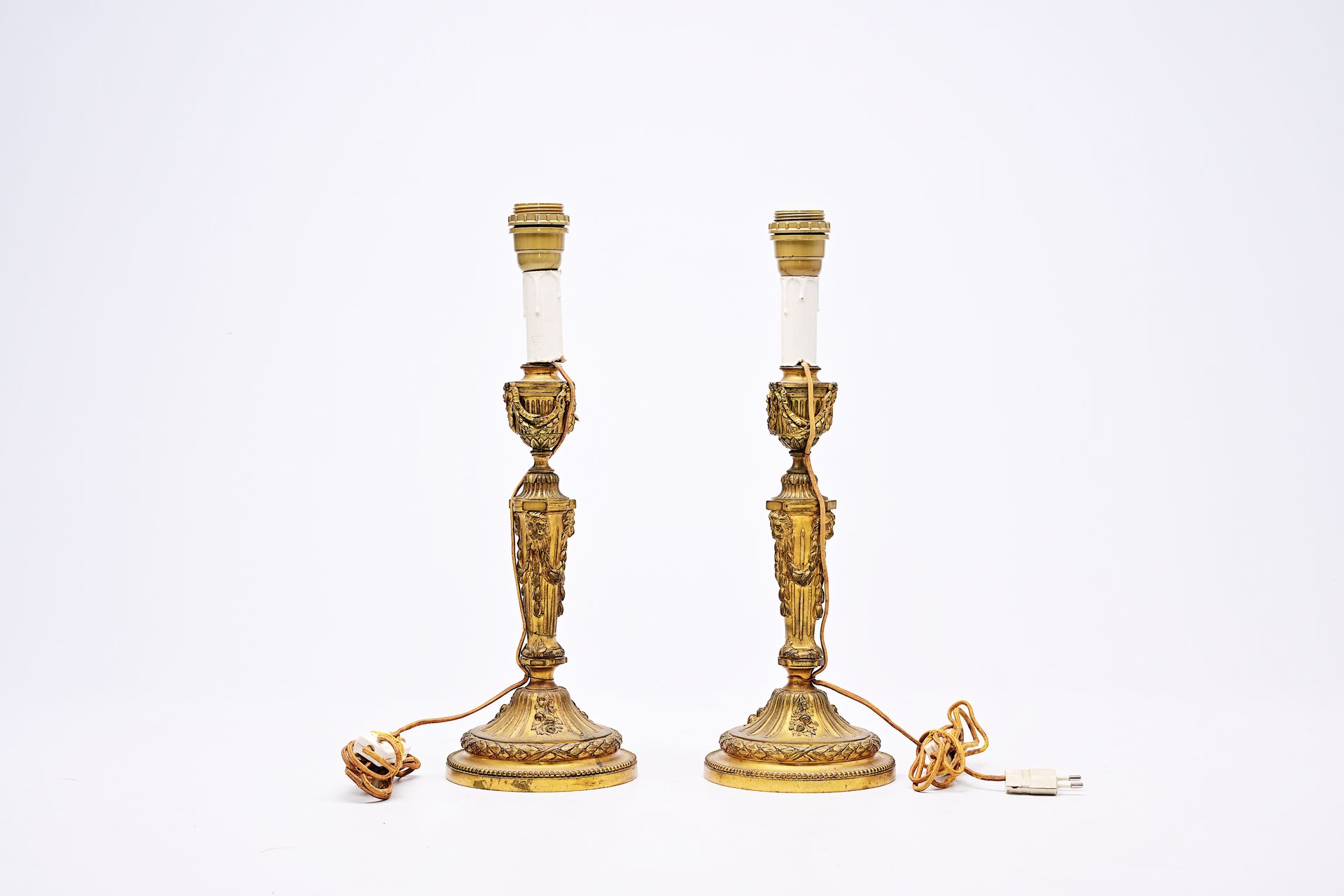 A pair of French Neoclassical gilt bronze candlesticks with lion heads and garla&hellip;