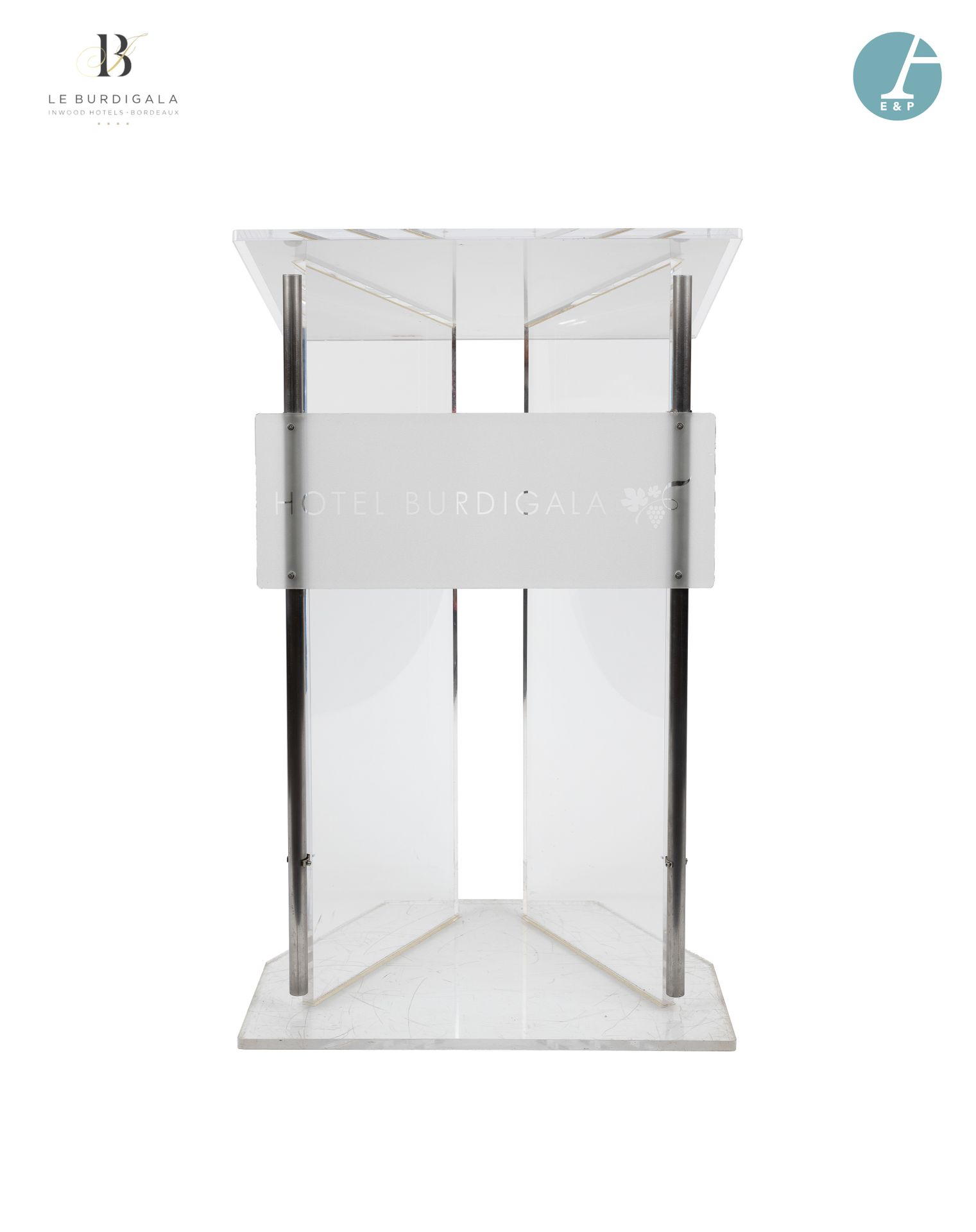 Null 从波尔多的4*酒店Burdigala出发



带金属管状立柱的有机玻璃办公桌，刻有酒店的名称。高：115厘米 - 宽：71厘米 - 深：57厘米
