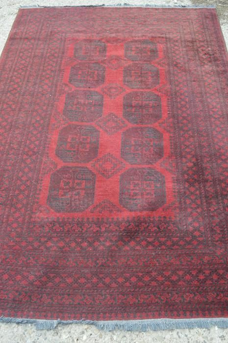 Null Un tapis à fond rouge avec des motifs octogonaux au centre, 164cm par 240cm
